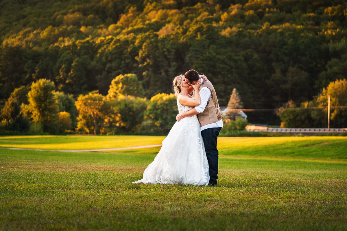 wedding couple kissing in front of a mountain
