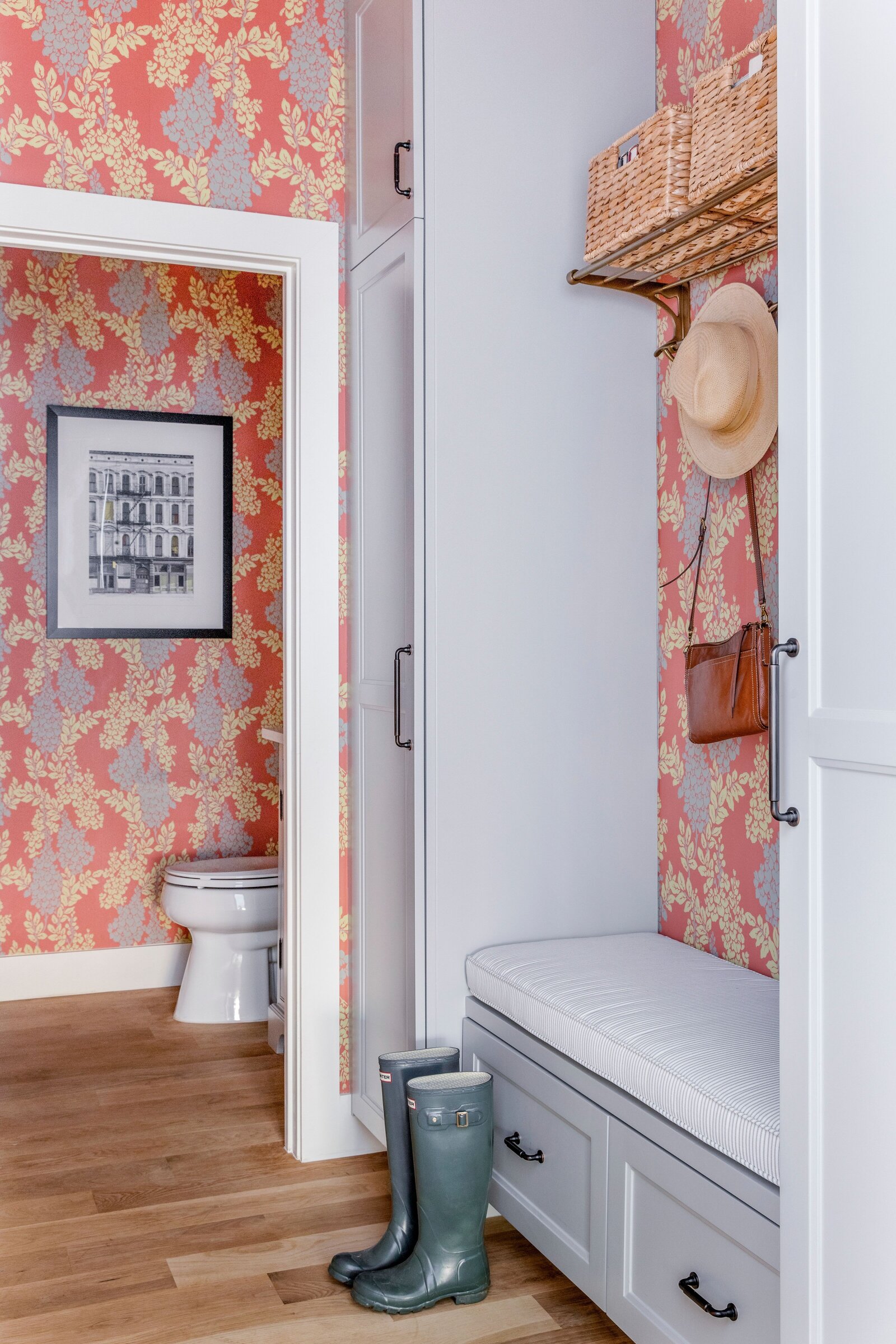 red floral wallpaper in a mudroom and guest bathroom. red mudroom with grey cabinets
