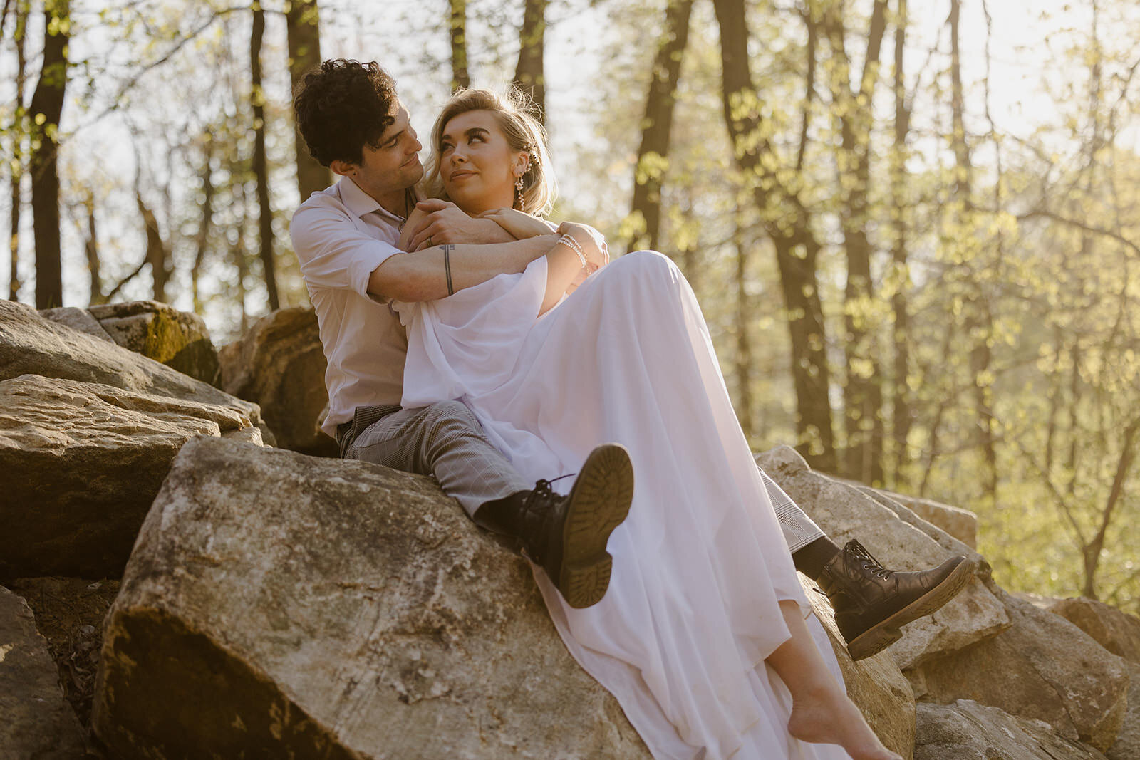A couple snuggling on a rock on their elopement day