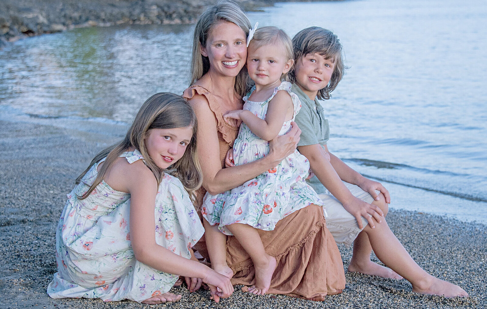 Mother and her two daughters and one son on the sand in a beach in Oahu