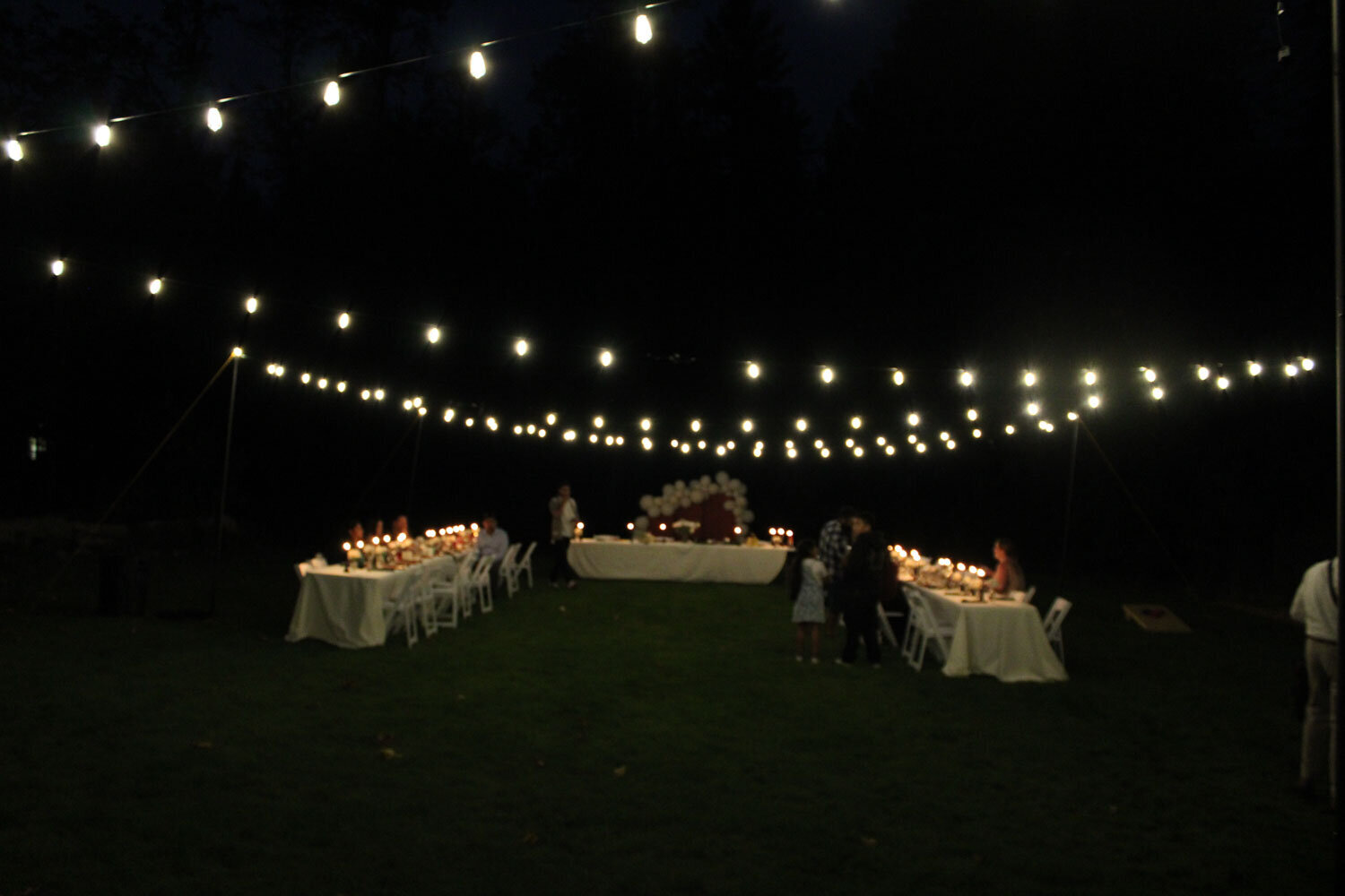 Evening outdoor reception with string lights and tables