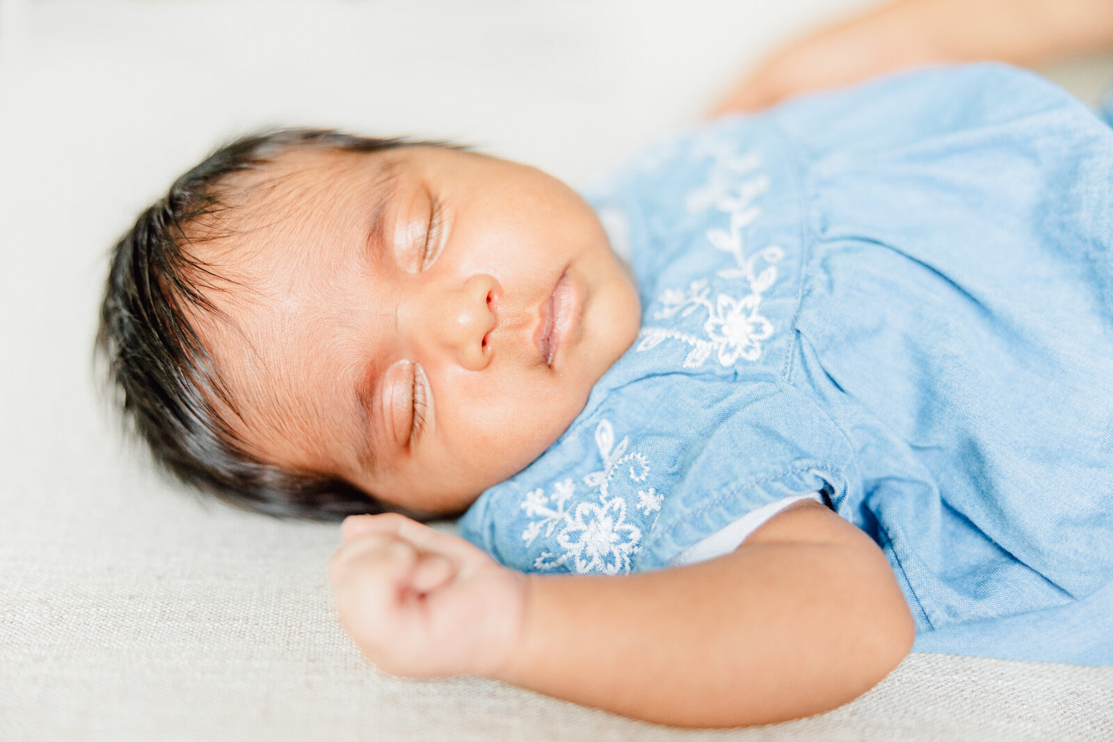 Newborn baby girl sleeps in a blue dress