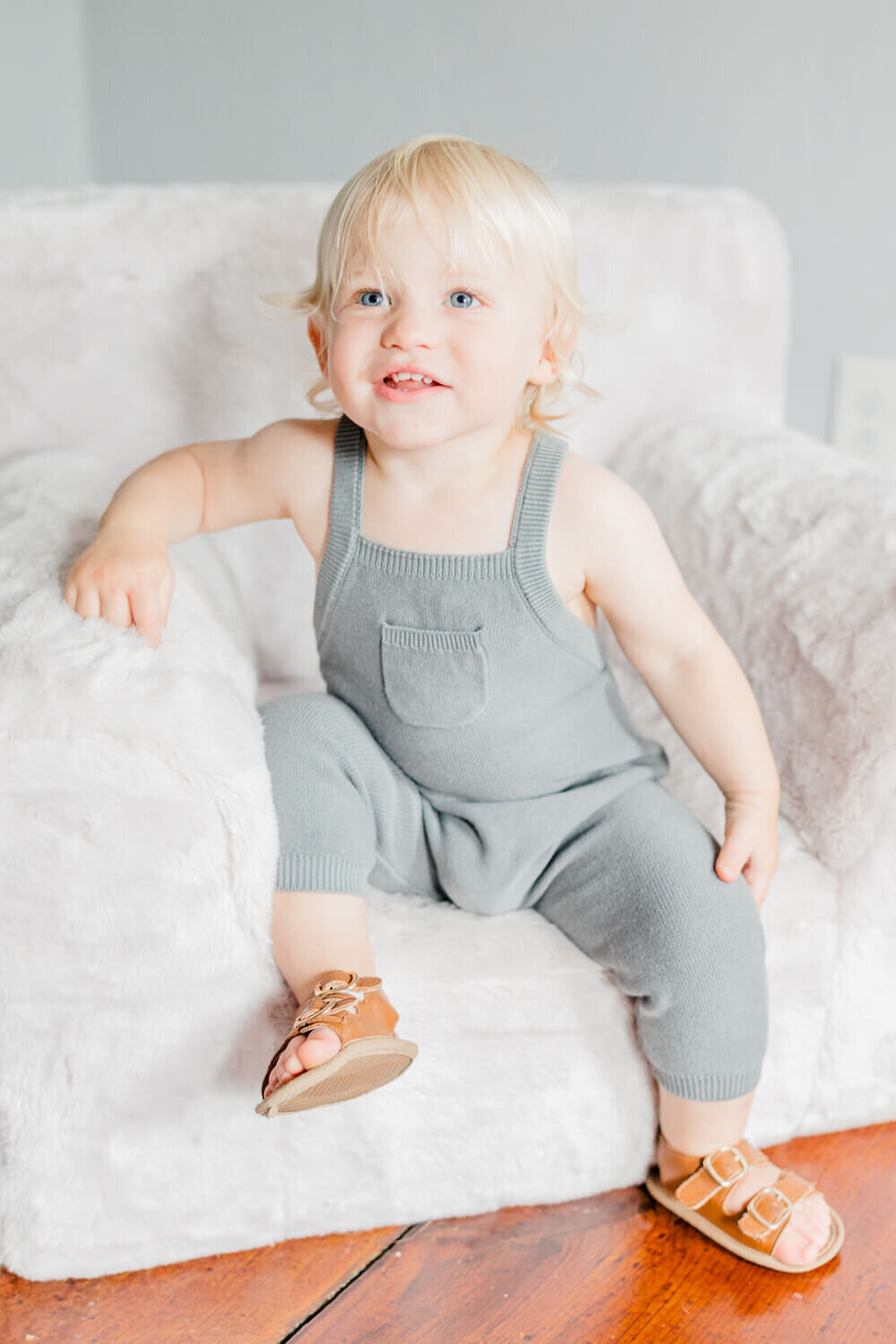 Toddler sits and smiles