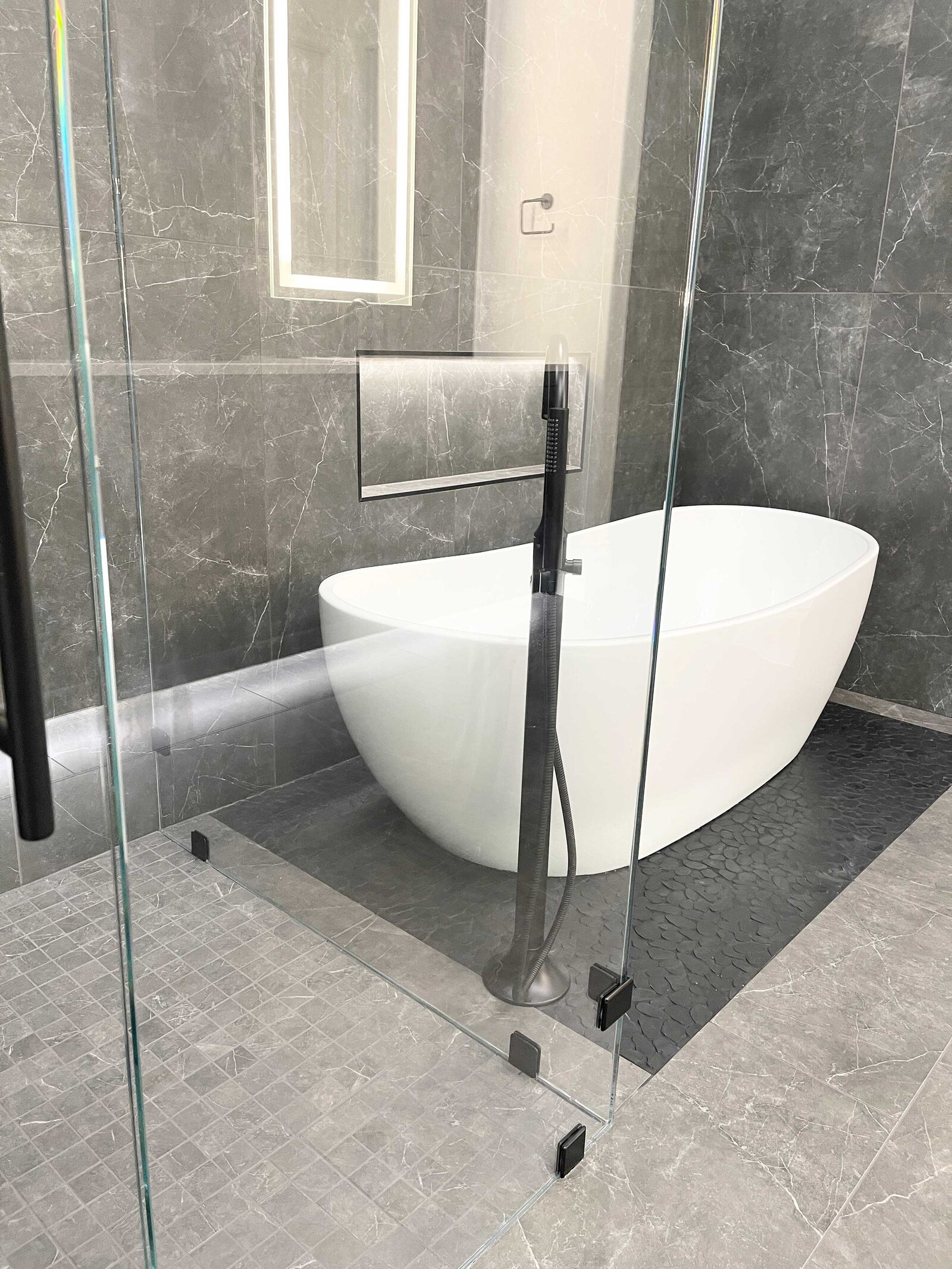 Professional home renovation design for a bathroom featuring a modern white tub, minimalist fixtures, and clean lines that create a sleek, contemporary atmosphere.