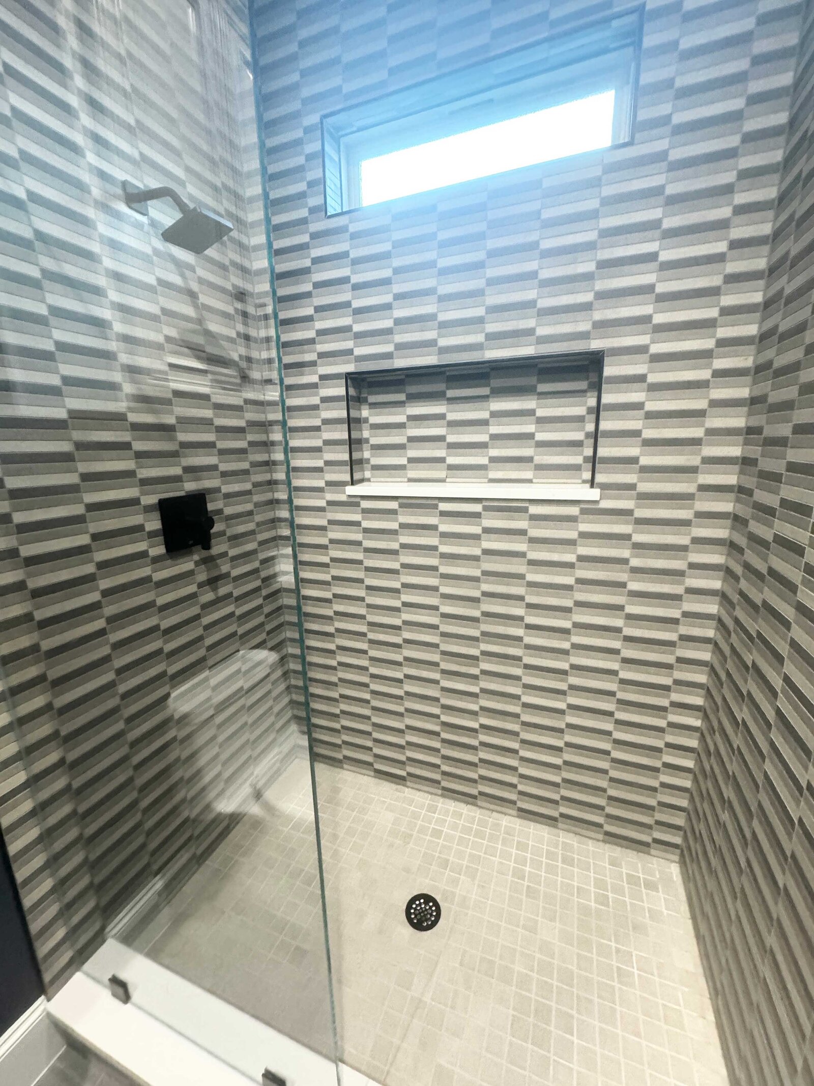 Luxury home renovation designer's work on a modern bathroom featuring high-end finishes, sleek fixtures, and a sophisticated, contemporary design tailored to elevate the home's aesthetic.