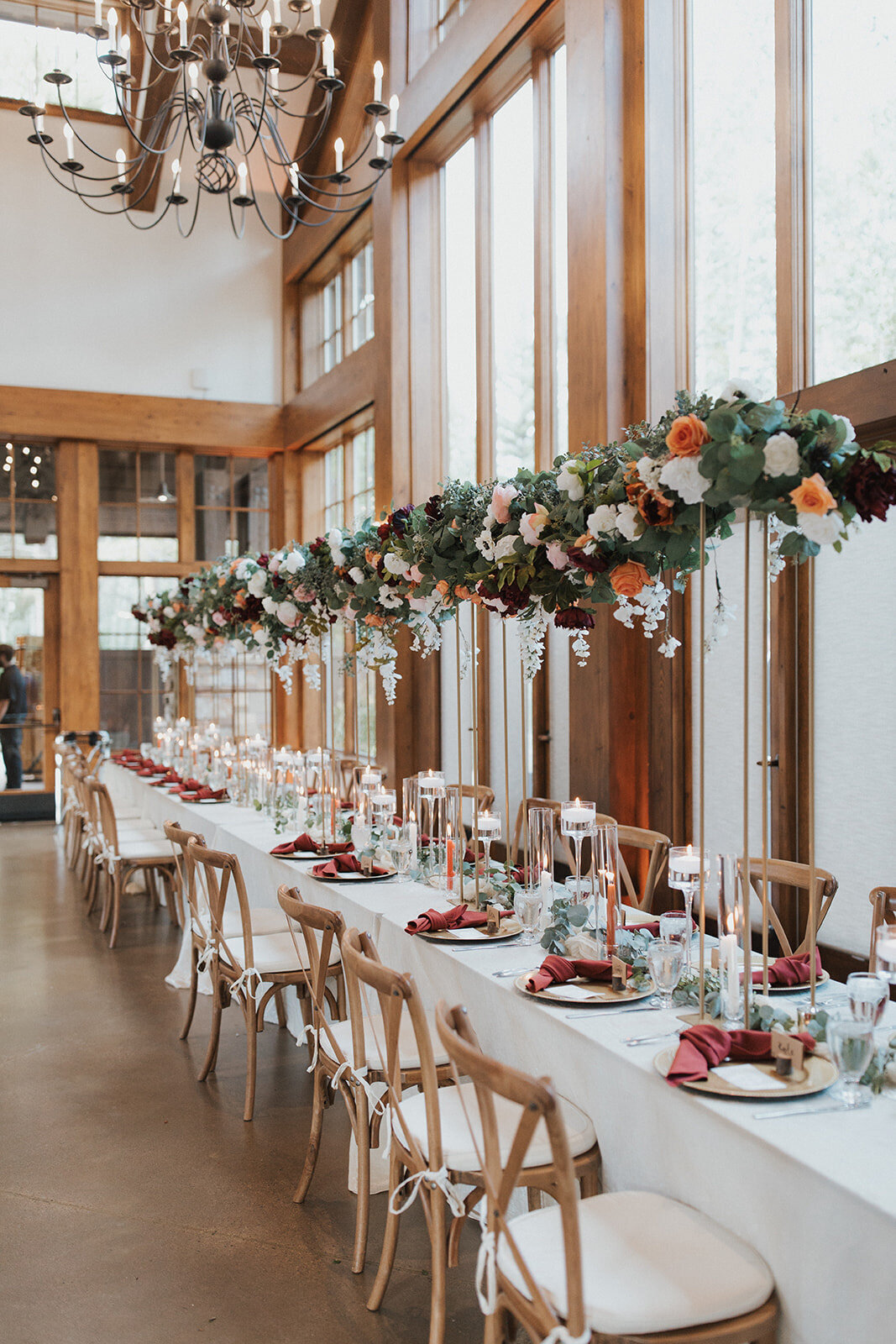 Luxurious wedding reception with tall floral centerpieces and table set-up