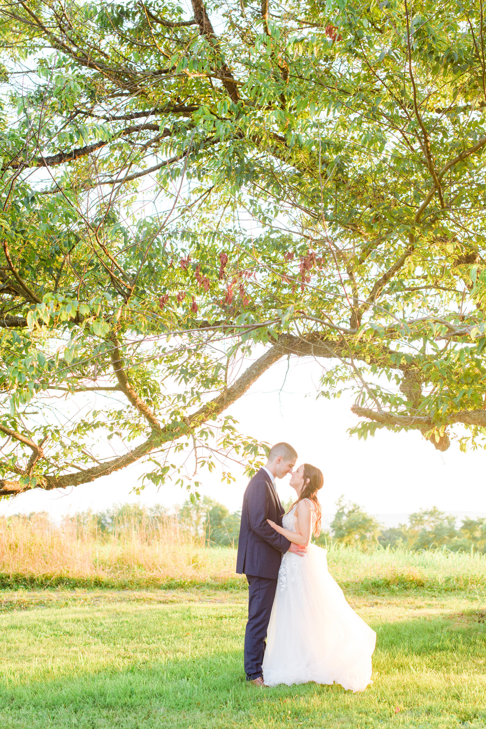 Couple embraces and smiles at sunset on their wedding day photographed by Cait Kramer Photography