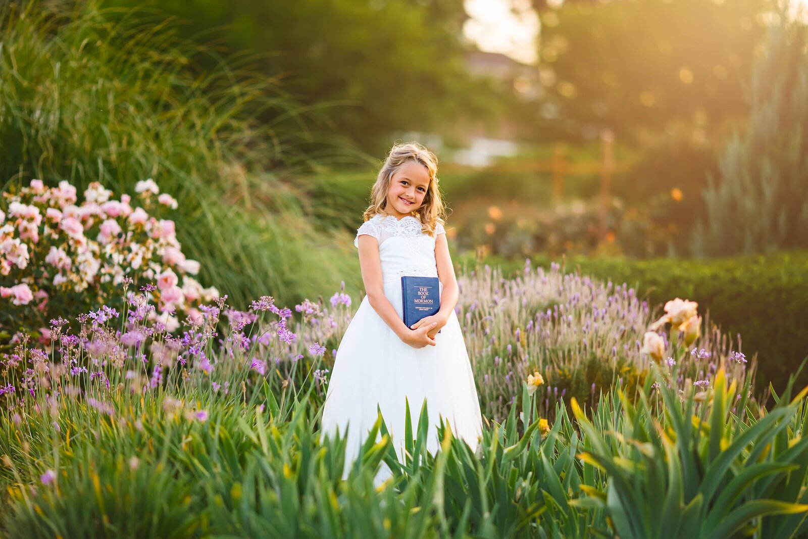 young girl posing with book in a flower field
