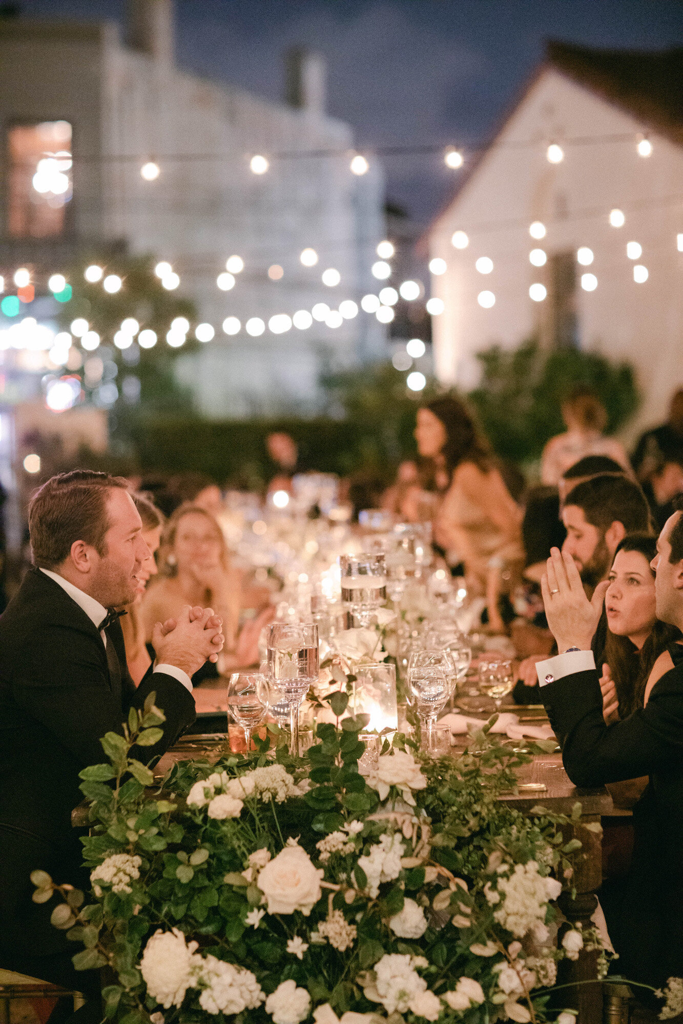 guests enjoying dinner at luxury wedding reception under lights