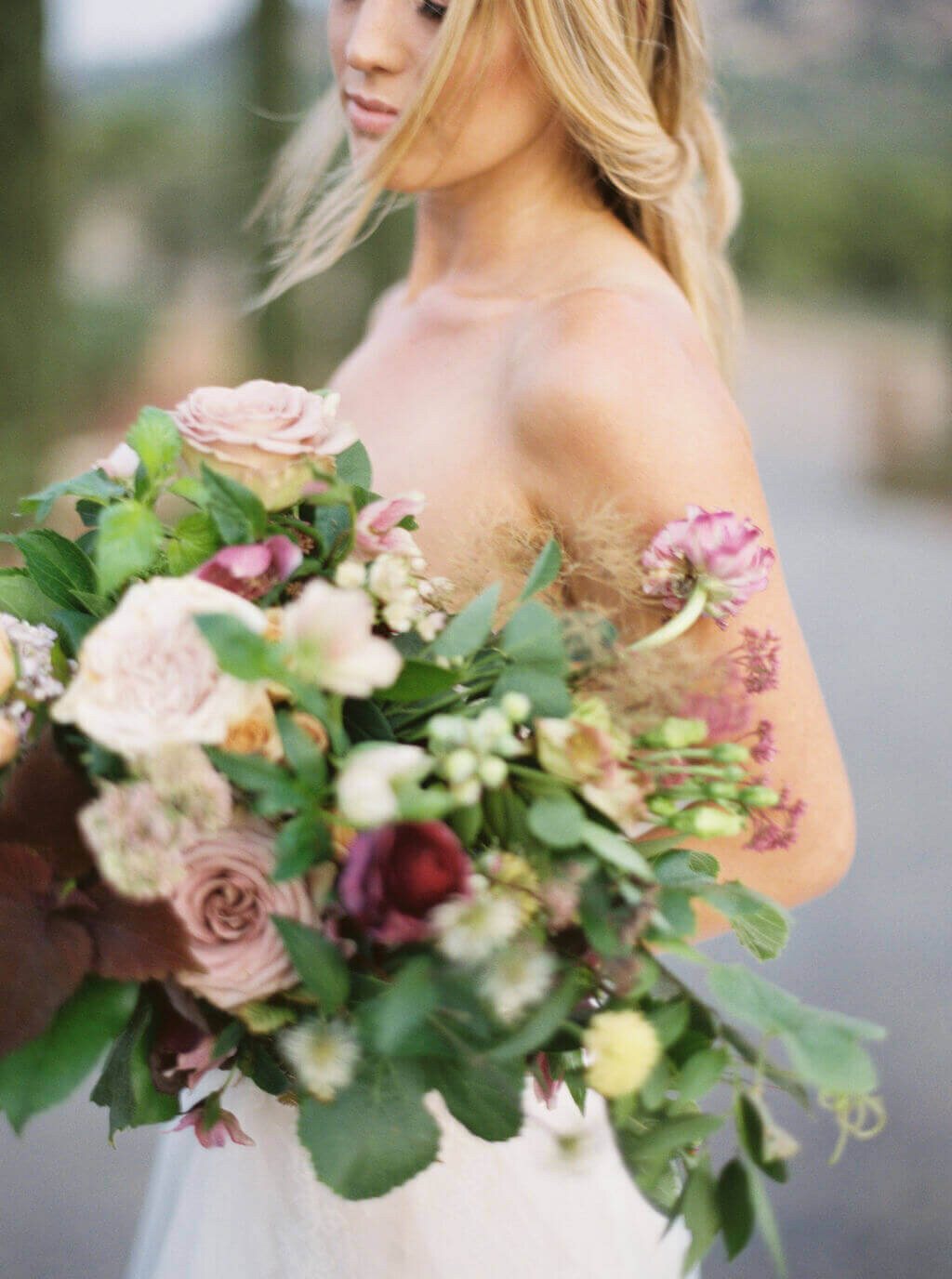 Bride holding a bouquet with white and muted pink flowers