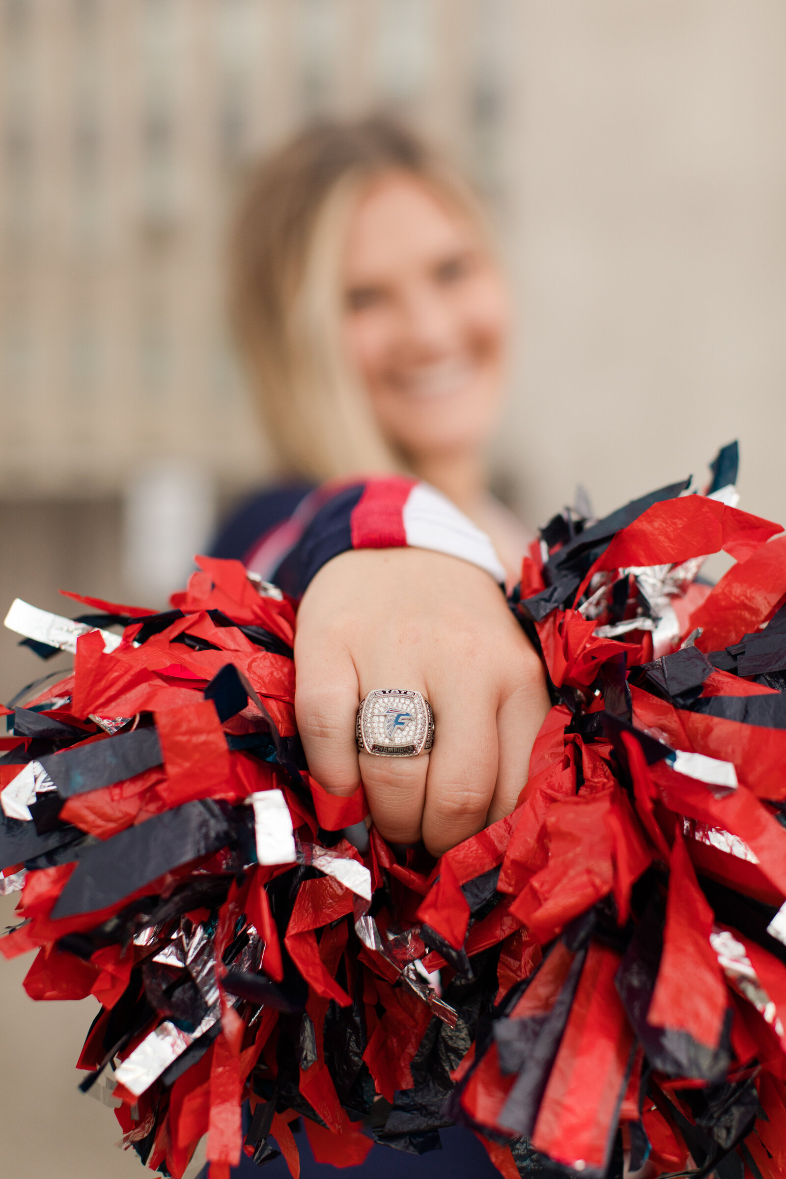 senior cheerleader with pom and state ring