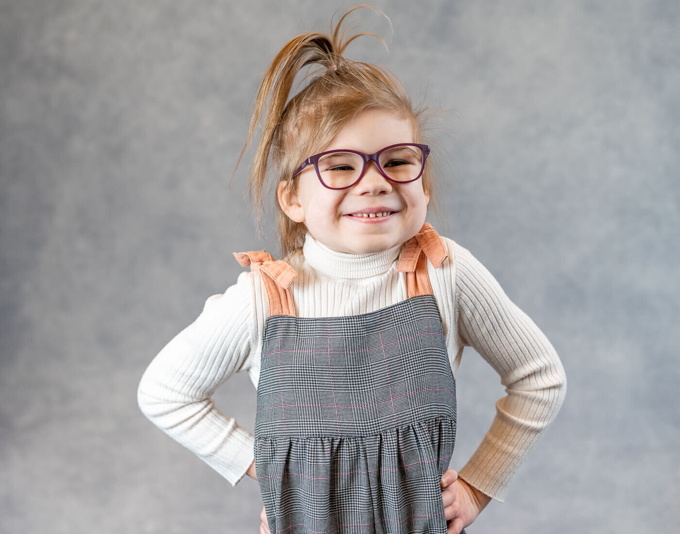 A child poses with their hands on their hips.