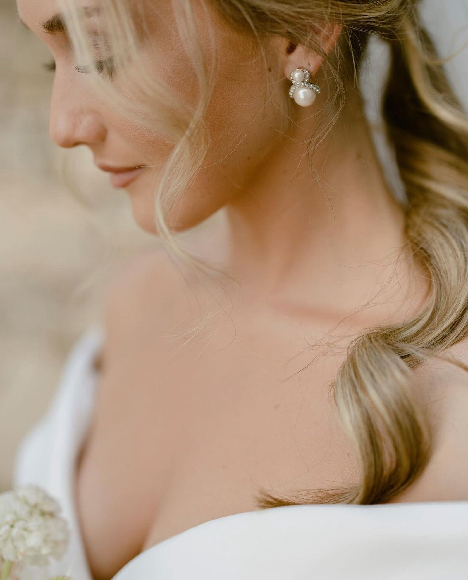 bride in her white-off shoulder wedding dress in a close up side profile