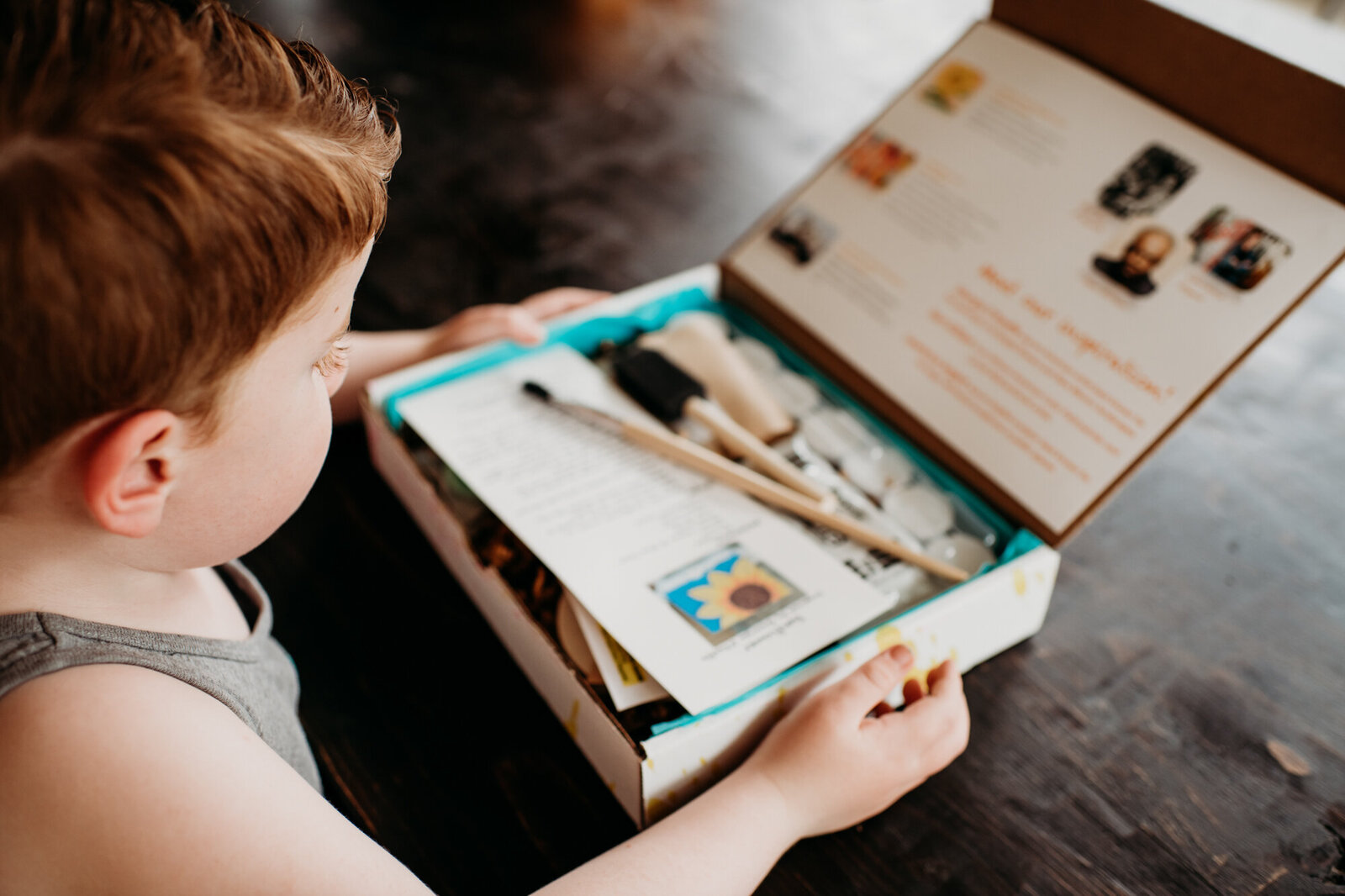 Branding Photographer,  a boy opens a box full of crafting materials