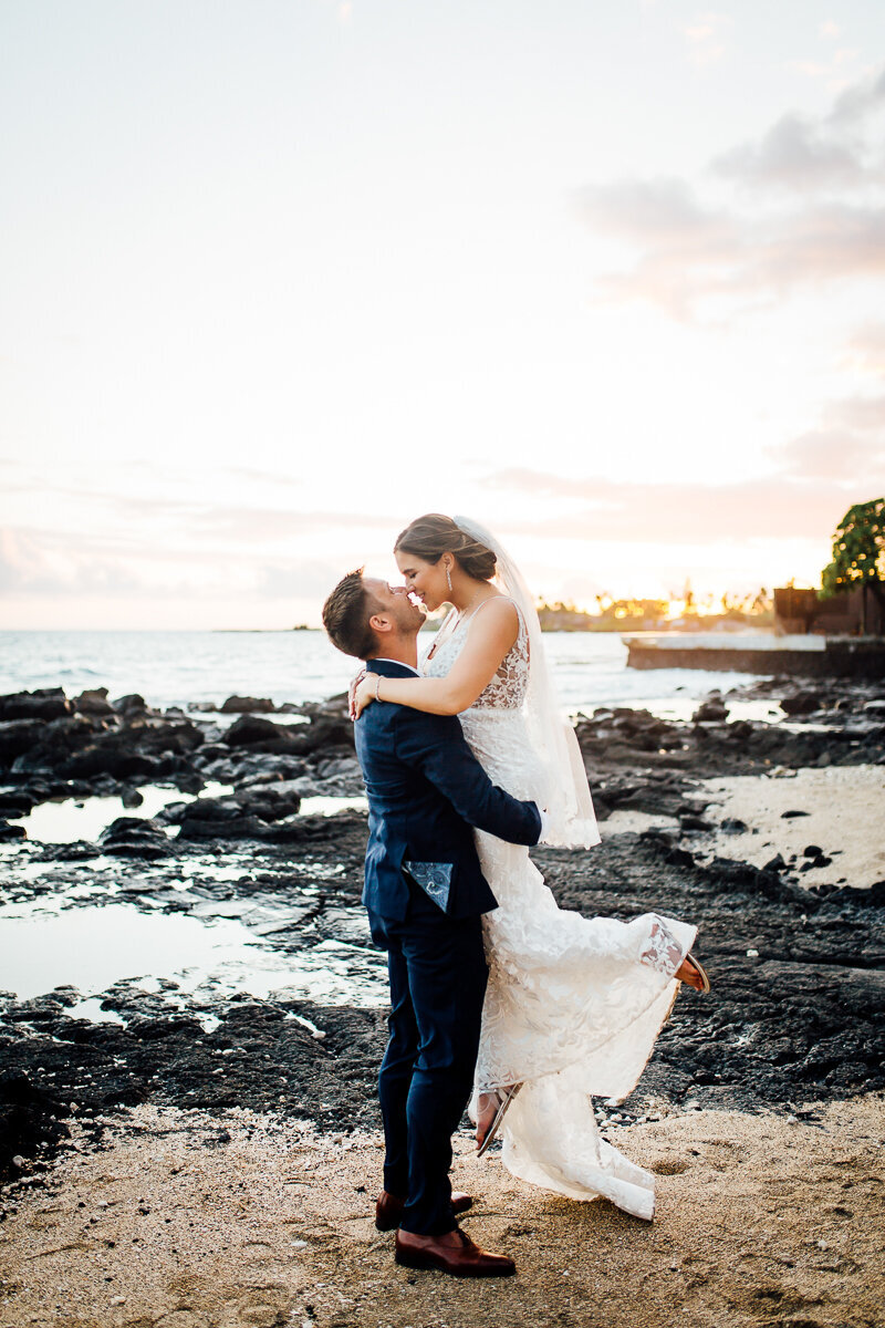 groom picks up and spin bride during their wedding day on the Big Island