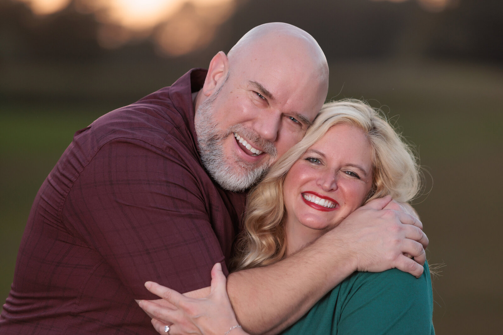 Husband and Wife hugging in a field for family portraits in Holly Springs NC.