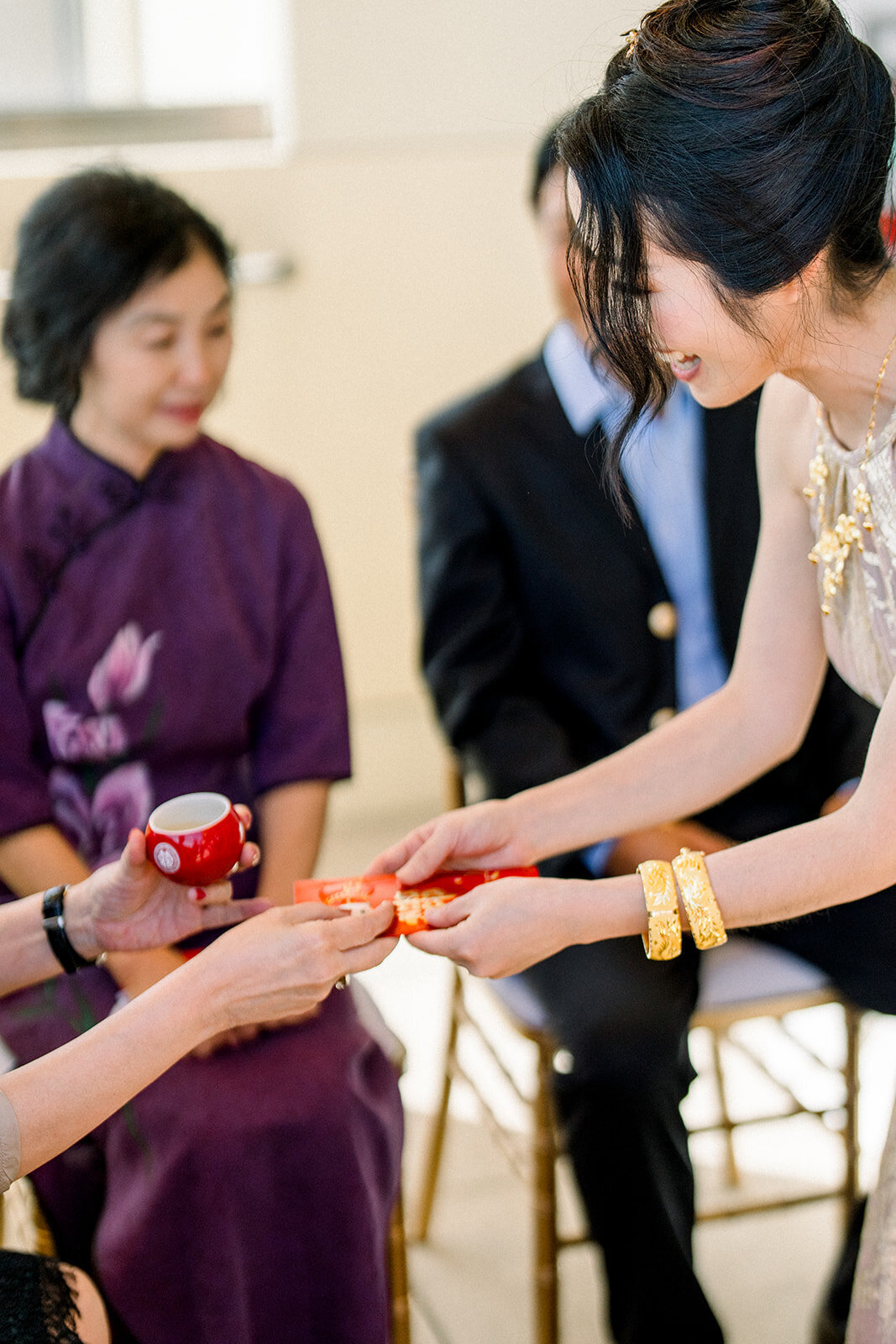 The bride and groom partake in a traditional tea ceremony with their family during their wedding at Stanford University.