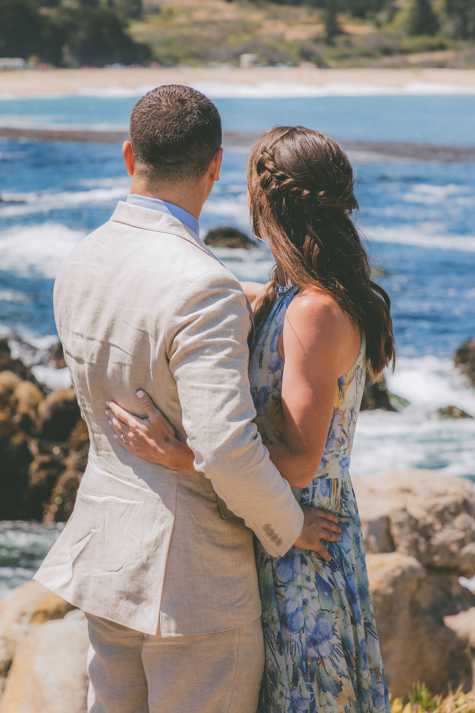 The backs of a couple looking at the ocean view during their Carmel Beach elopement.