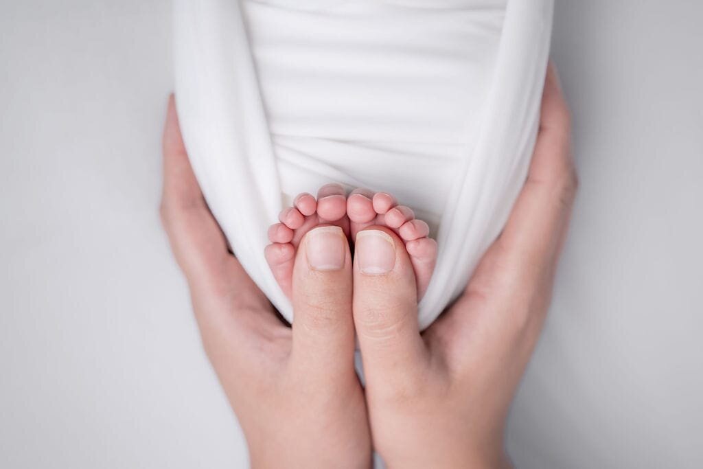 Tiny toes get wrapped around mama's thumbs during this precious newborn session in Lynnwood, Wa, with Thistle and Bloom Photography