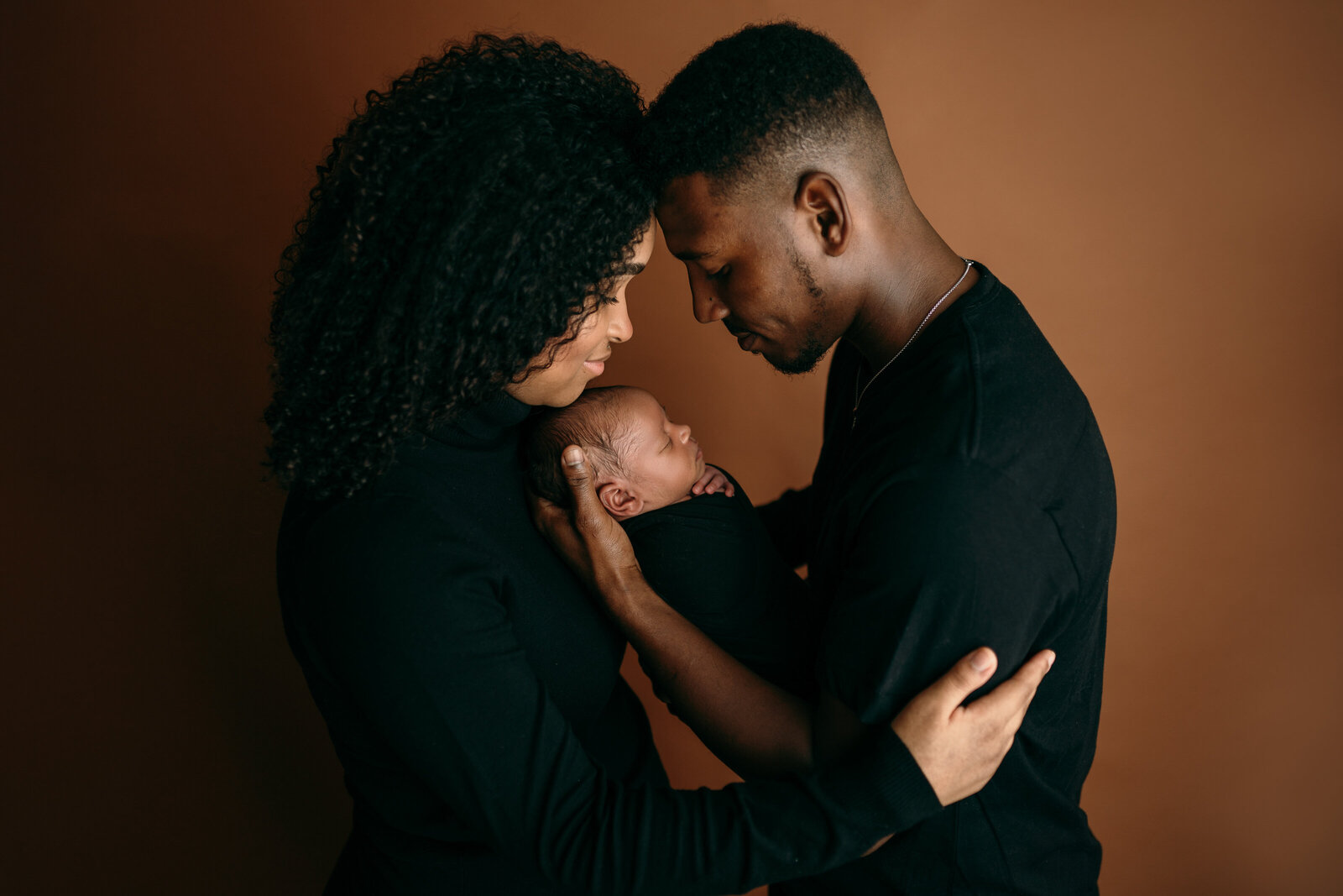 parents and newborn baby pose during photo session in Tampa