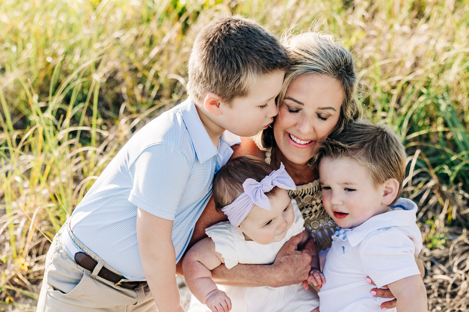 Loving photo of a grandma holding her grandchildren on the beach near st. pete