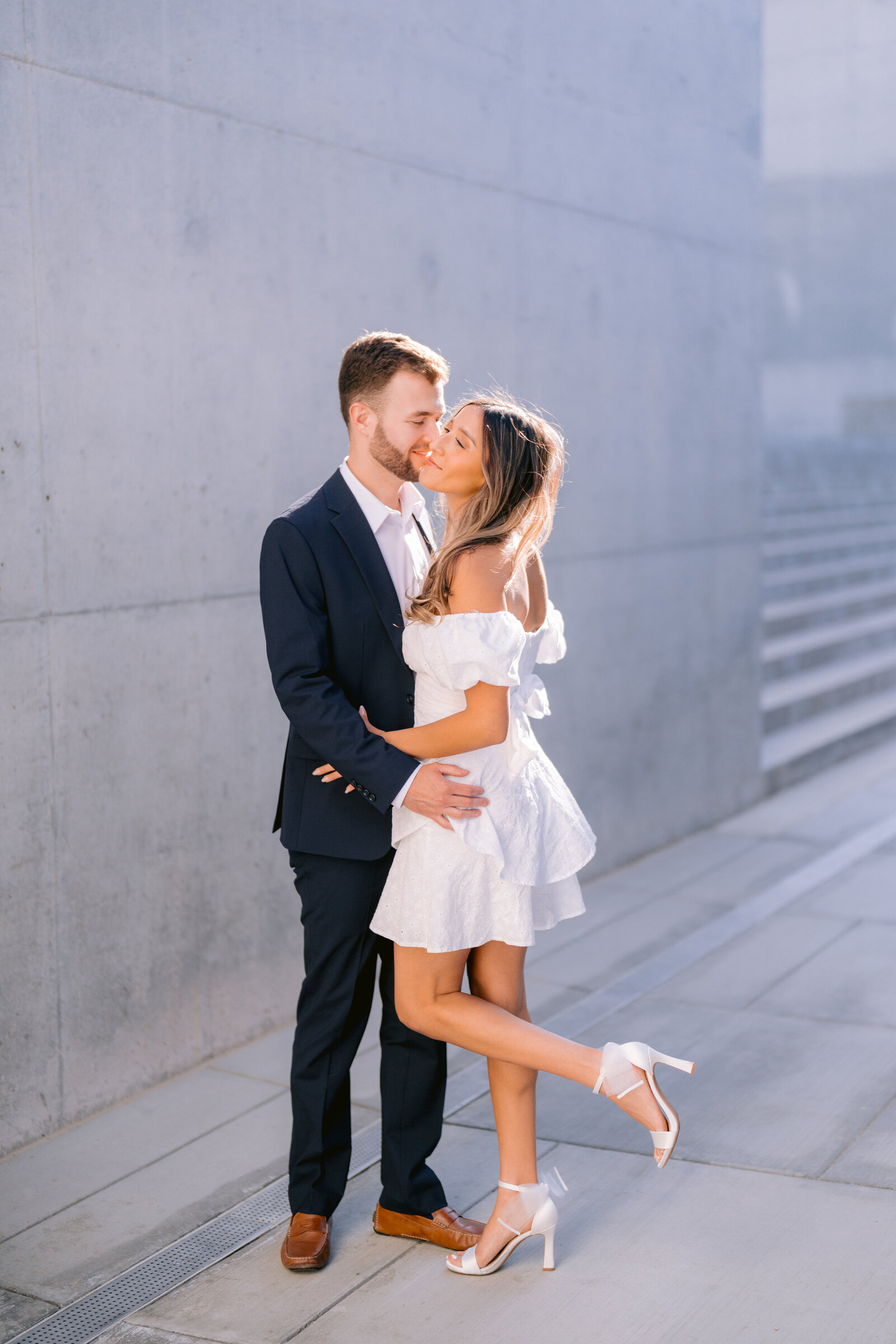 Engagement photo of a dressed up couple kissing in downtown Phoenix Arizona