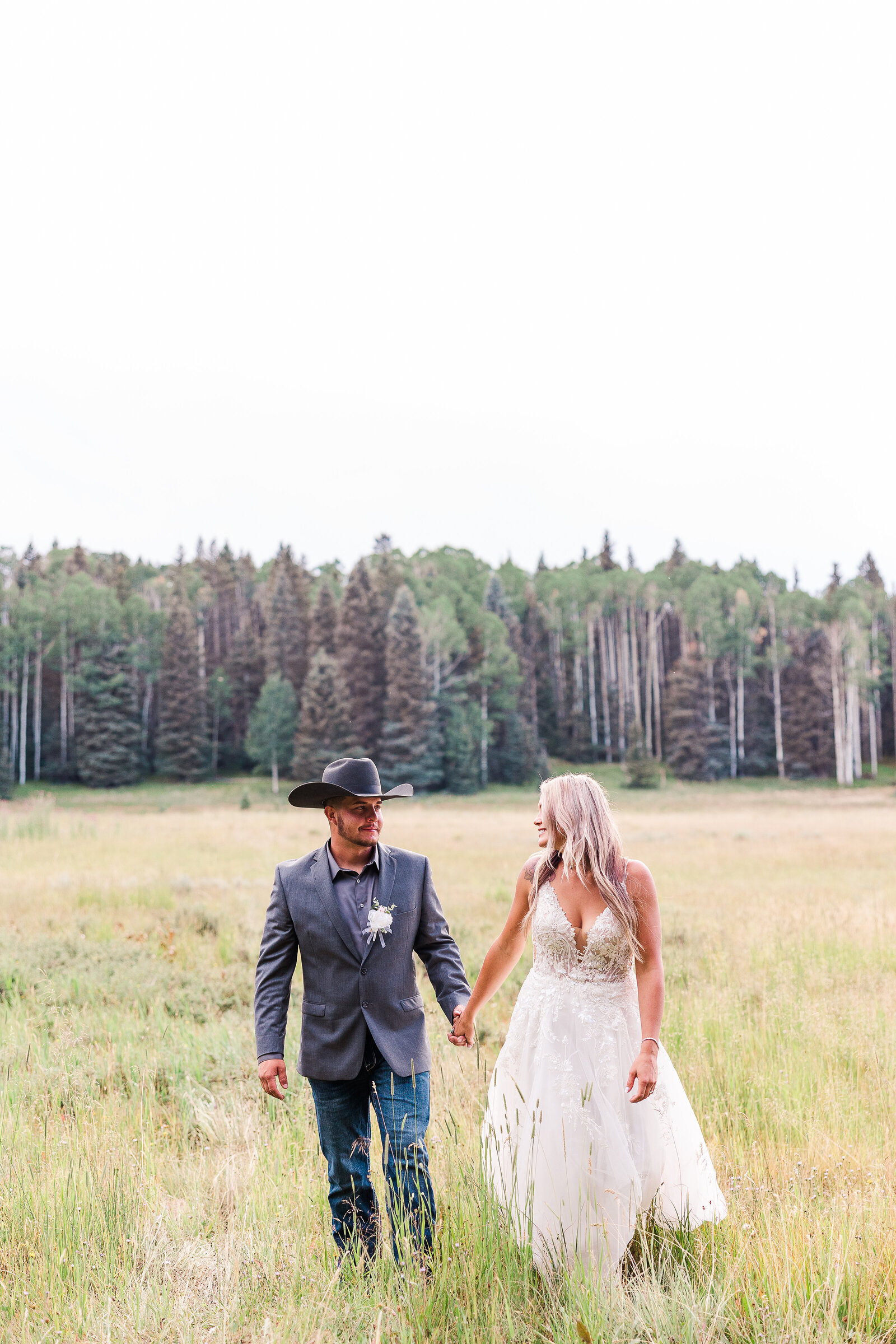 Newlyweds run and laugh in the field