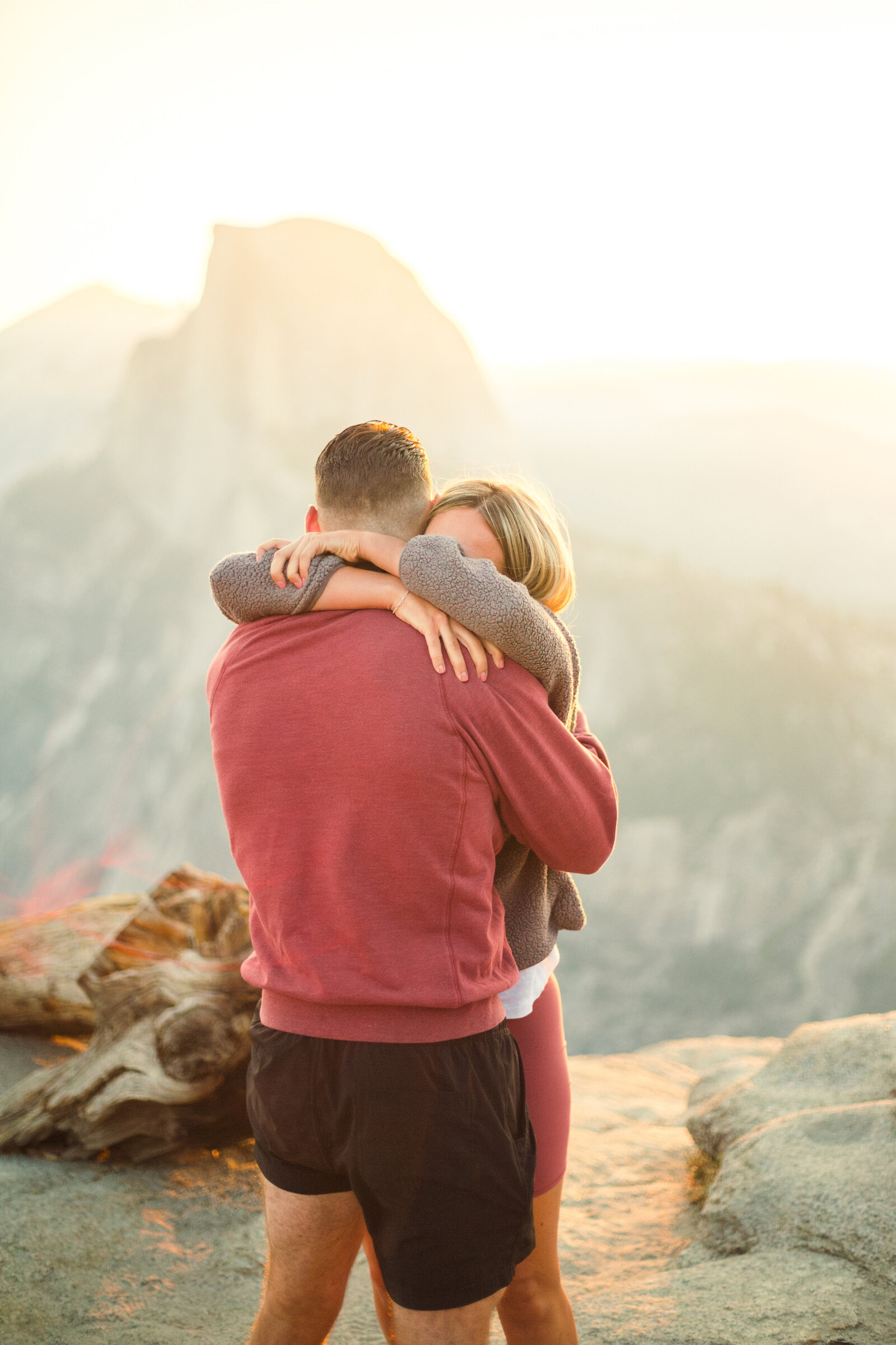 A wedding proposal between two hikers at sunrise in front of Half Dome in Yosemite National Park.