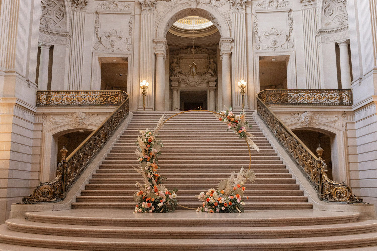 Elegant wedding staircase with floral arch for ceremony