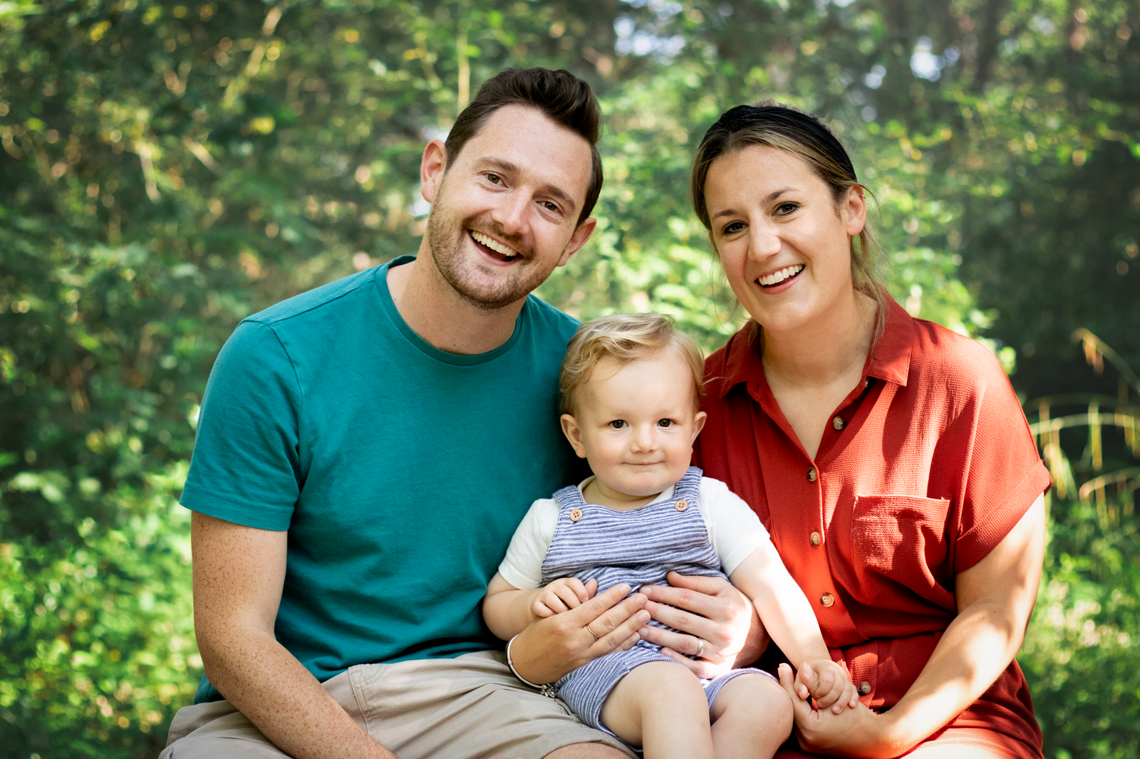 Family smile at the camera for a photo in a park in Devon