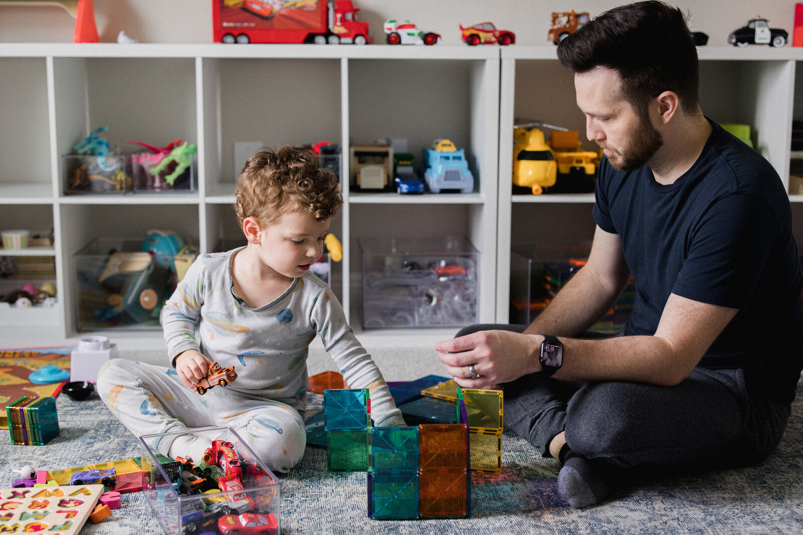 Dad and son building colorful tower in playroom
