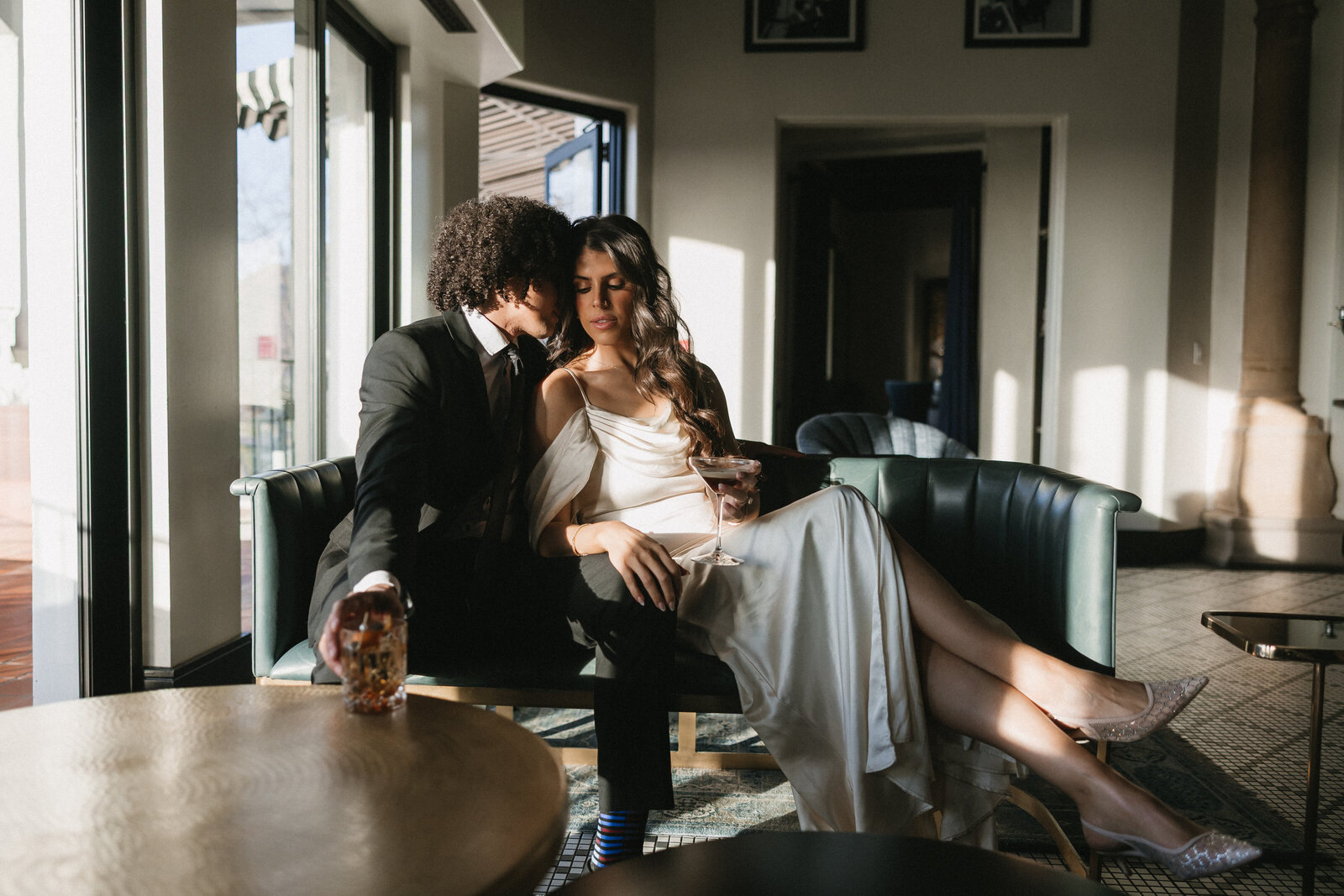 Engaged couple sitting on couch embracing each other captured by Arizona engagement photographer