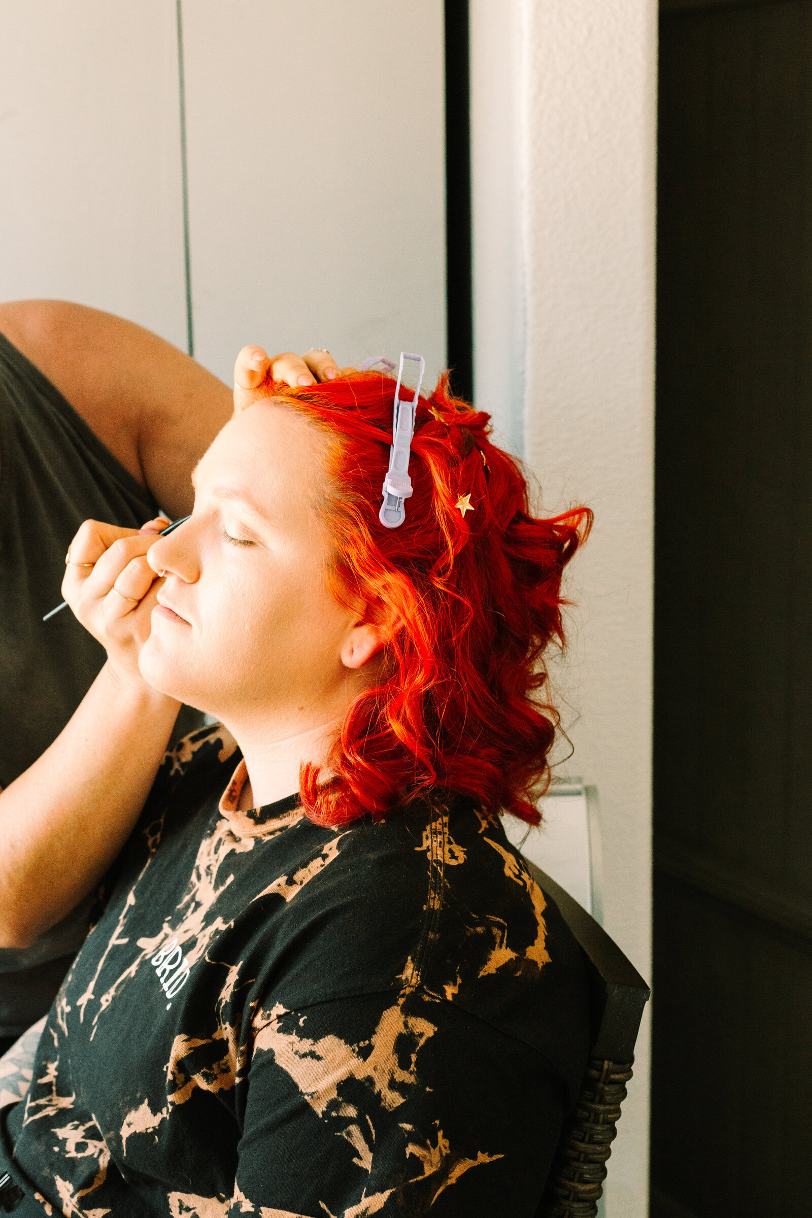 A bride with red hair and tattoos gets ready on her wedding day.