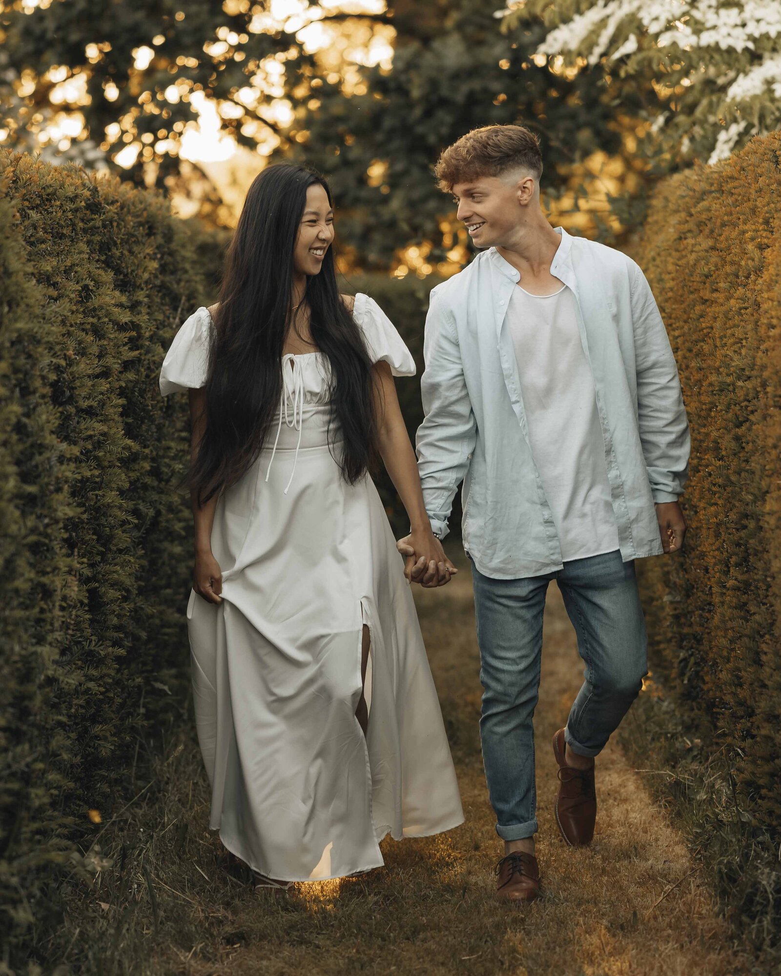 couple walking between hedges