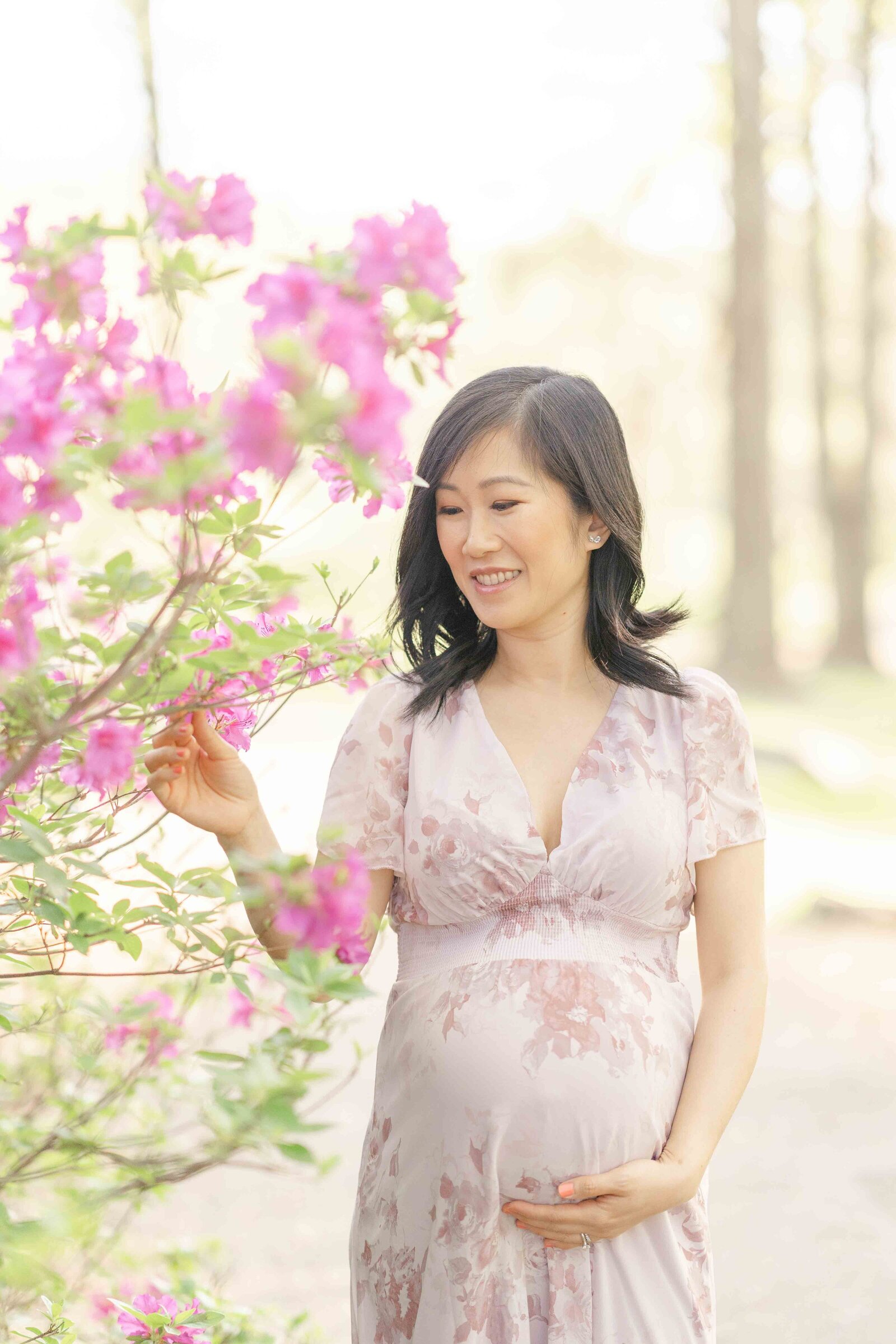 mom touching flowers during Ashburn, Virginia maternity picture