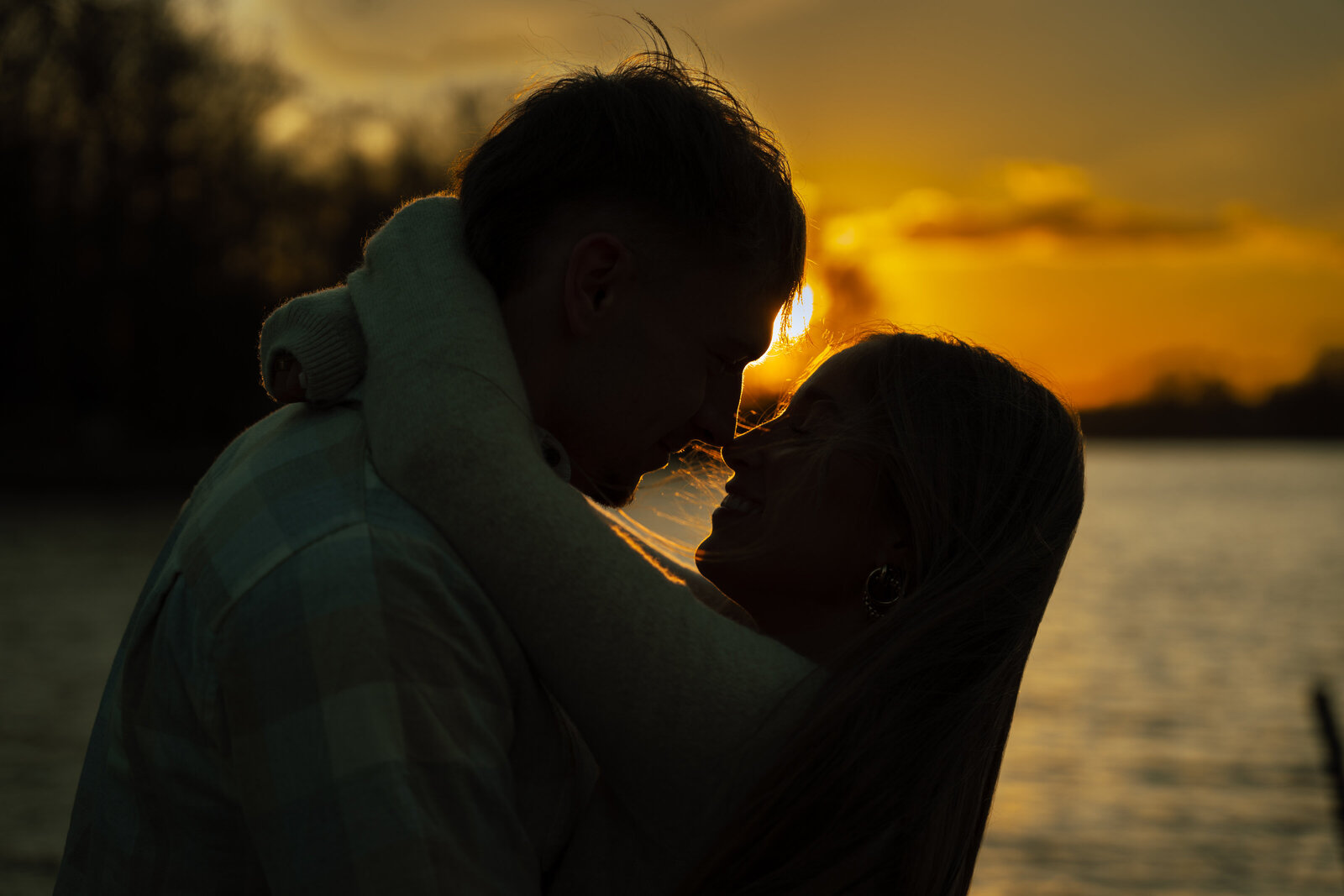 Couple snuggling nose to nose with a Tennessee sunset behind them.