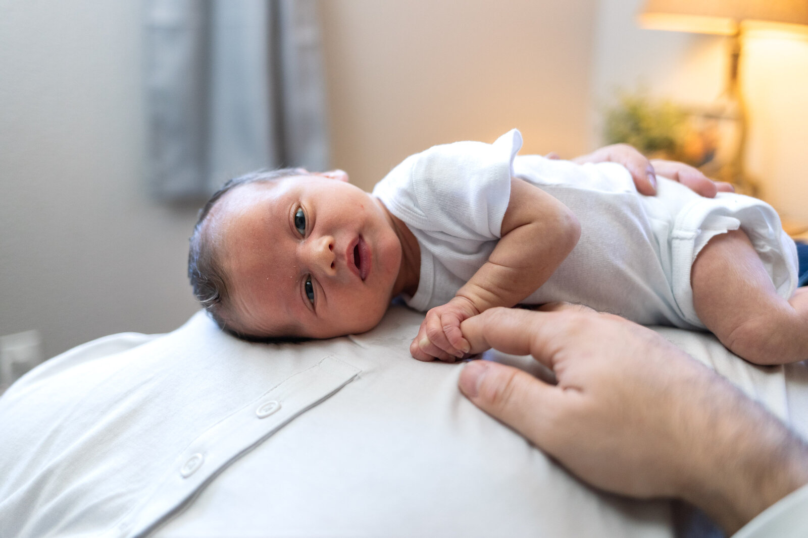 Kansas_City_Newborn_Photography_baby_open_eyes_laying_on_dad-17
