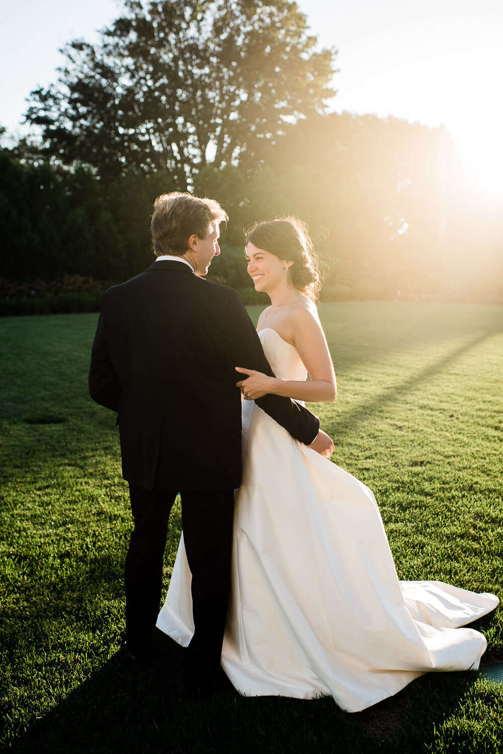 bride and groom hug with sun flare