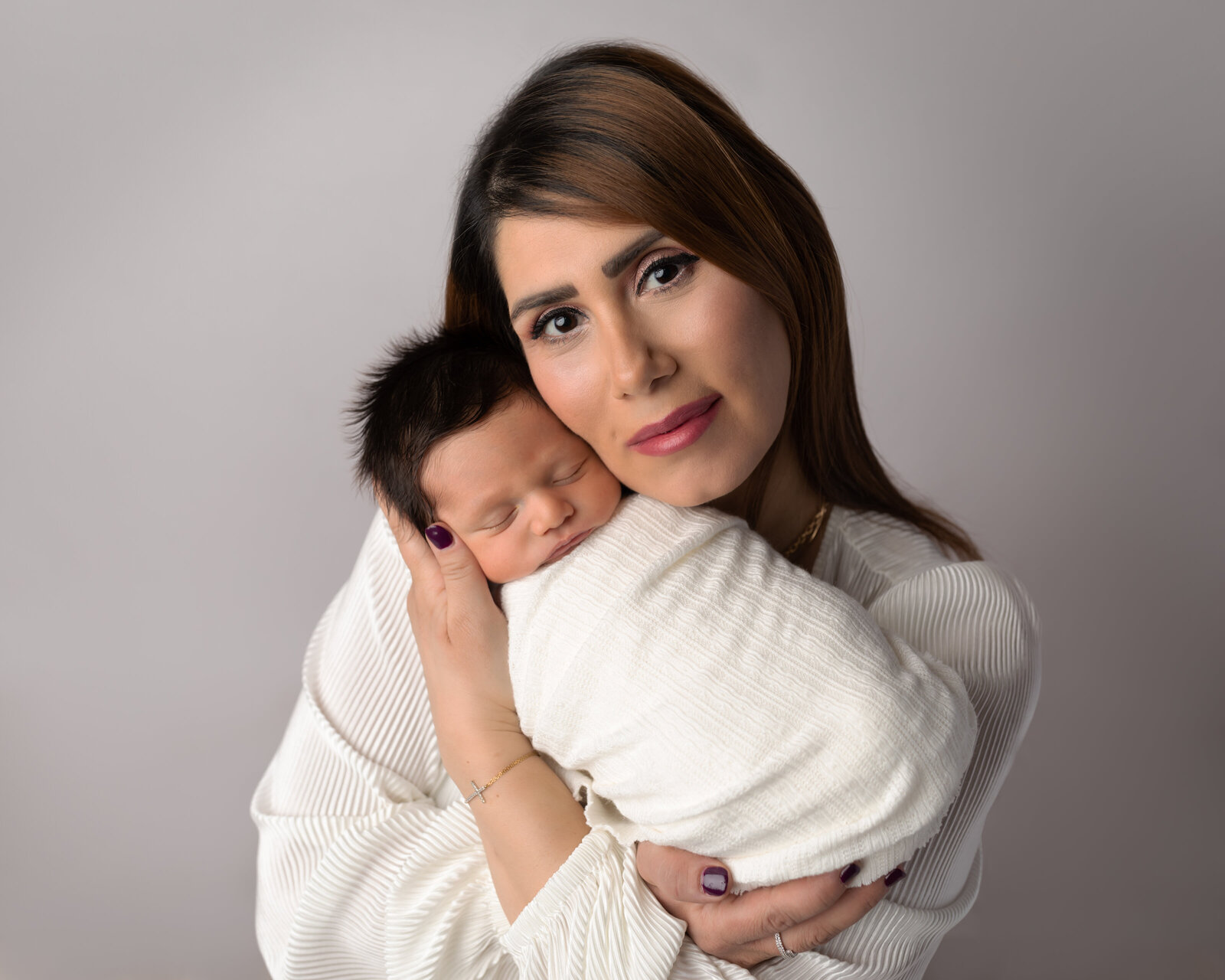 mom holding newborn baby boy for studio portrait