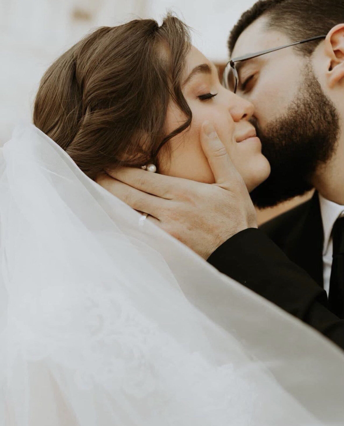 bride and groom kissing on cheek