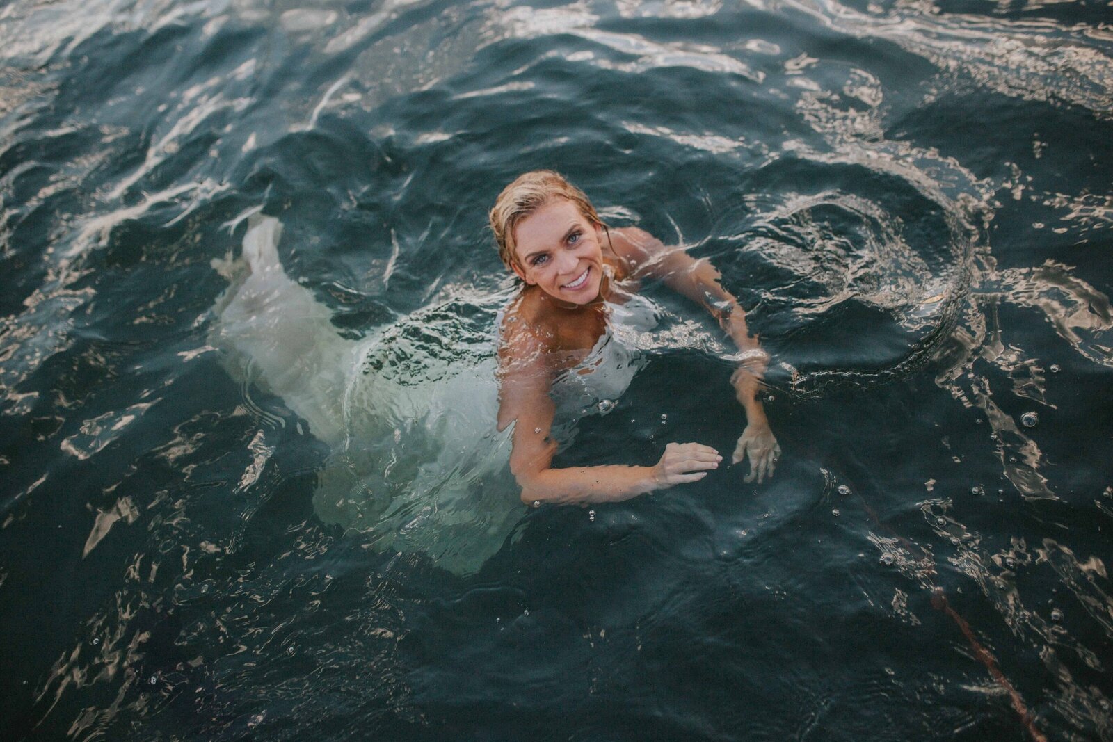 Sacramento Wedding Photographer captures bride swimming in water wearing wedding dress