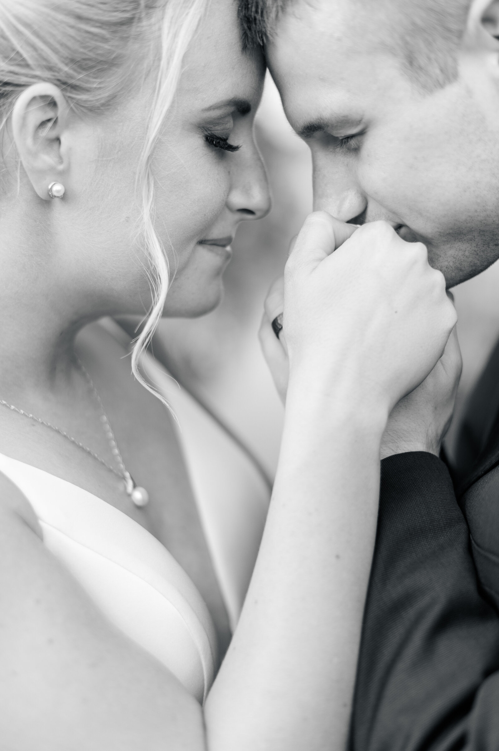 Groom kissing bride's hand captured by the Best Boise Wedding Photographers in black and white