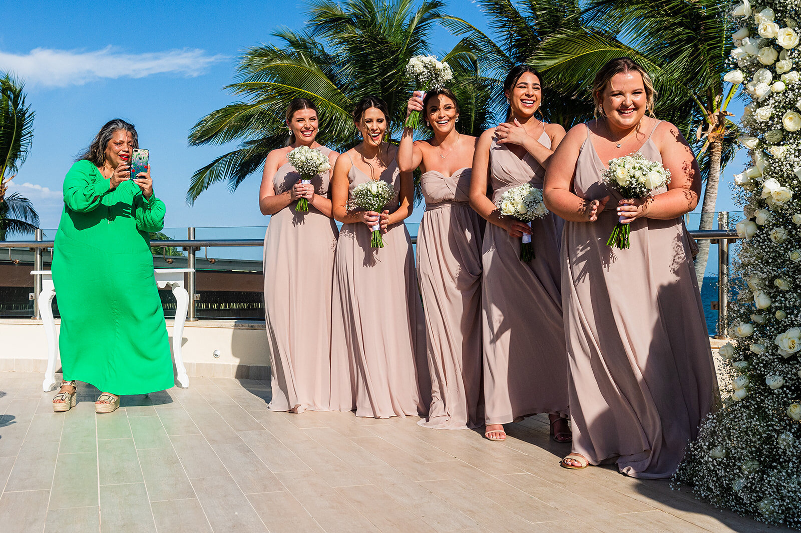 A group of bridesmaids posing outdoors in elegant formal dresses before the wedding ceremony, captured by CMH Studios