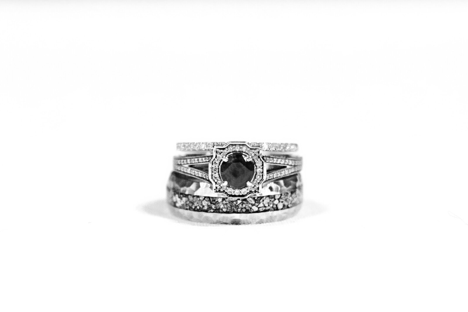 A stunning black diamond wedding ring set with intricate detailing, captured on a clean white background during a Wilmington, NC wedding, showcasing timeless elegance and unique bridal jewelry.