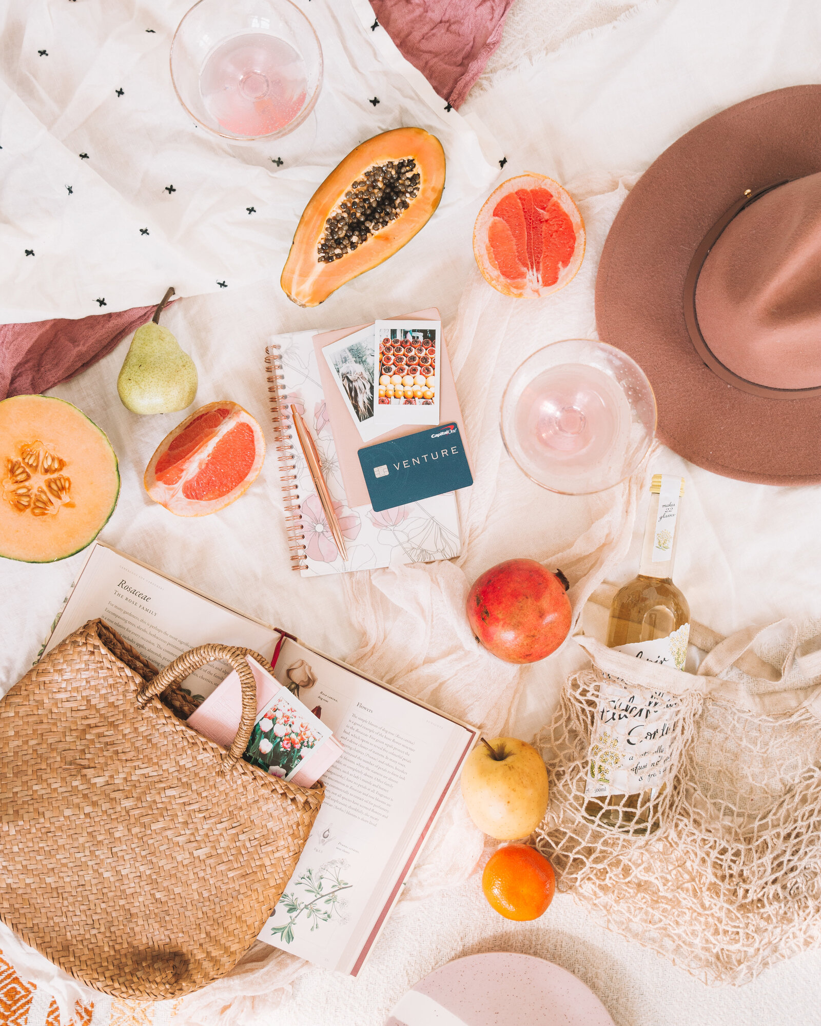 Capital One Venture Credit Card flat lay travel blogger The Blonde Abroad with hat papaya summer fruit styling by Chelsea Loren