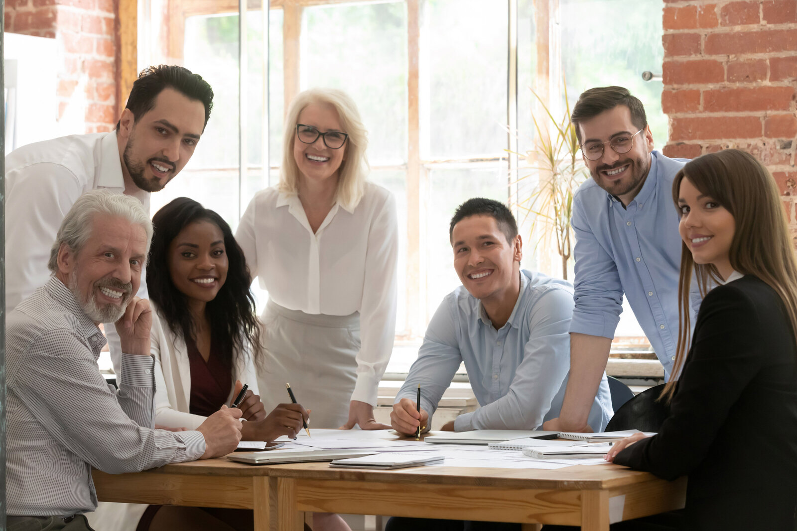 Happy employees smiling around an office conference table