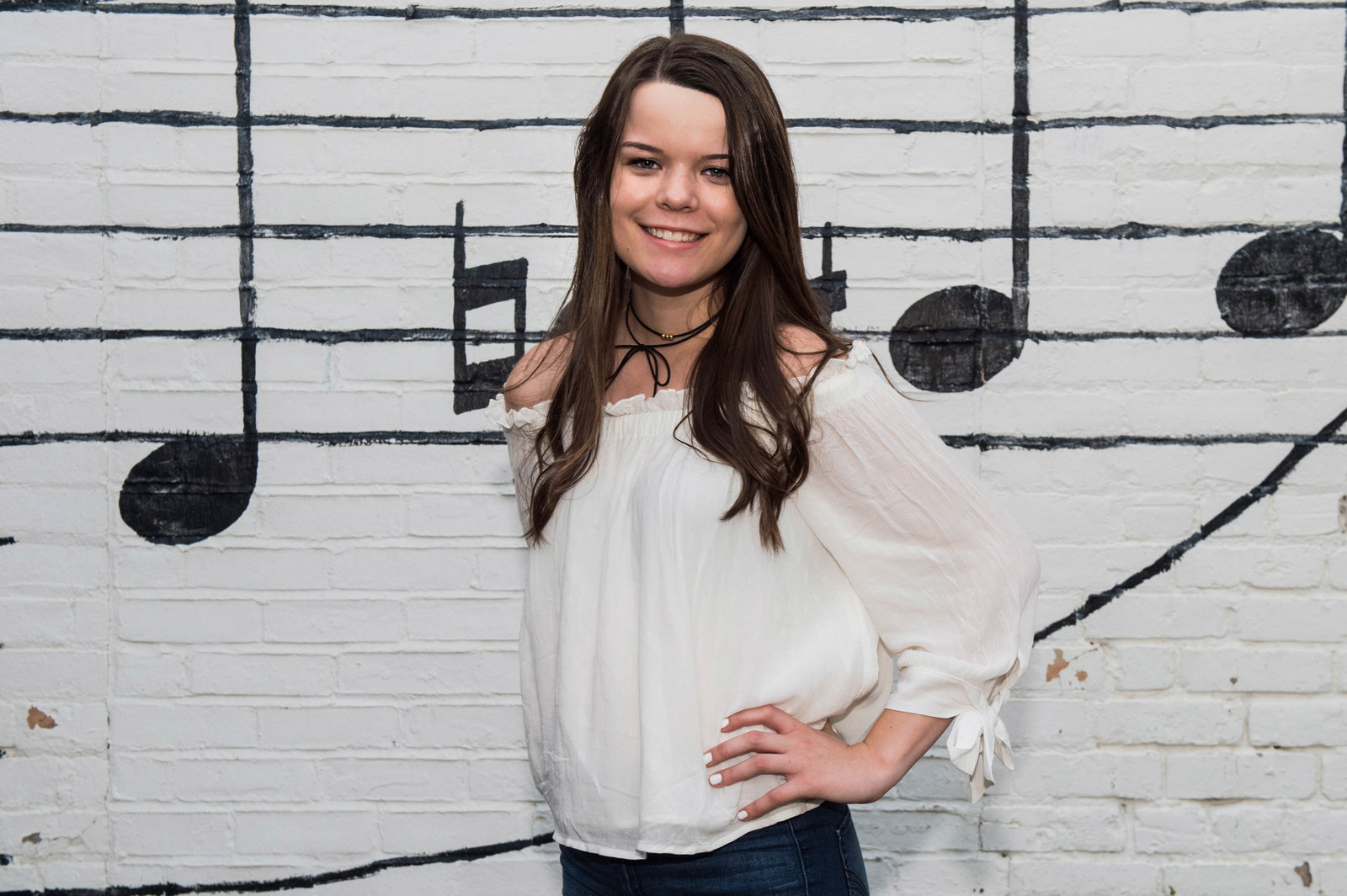Senior girl stands in front of music wall