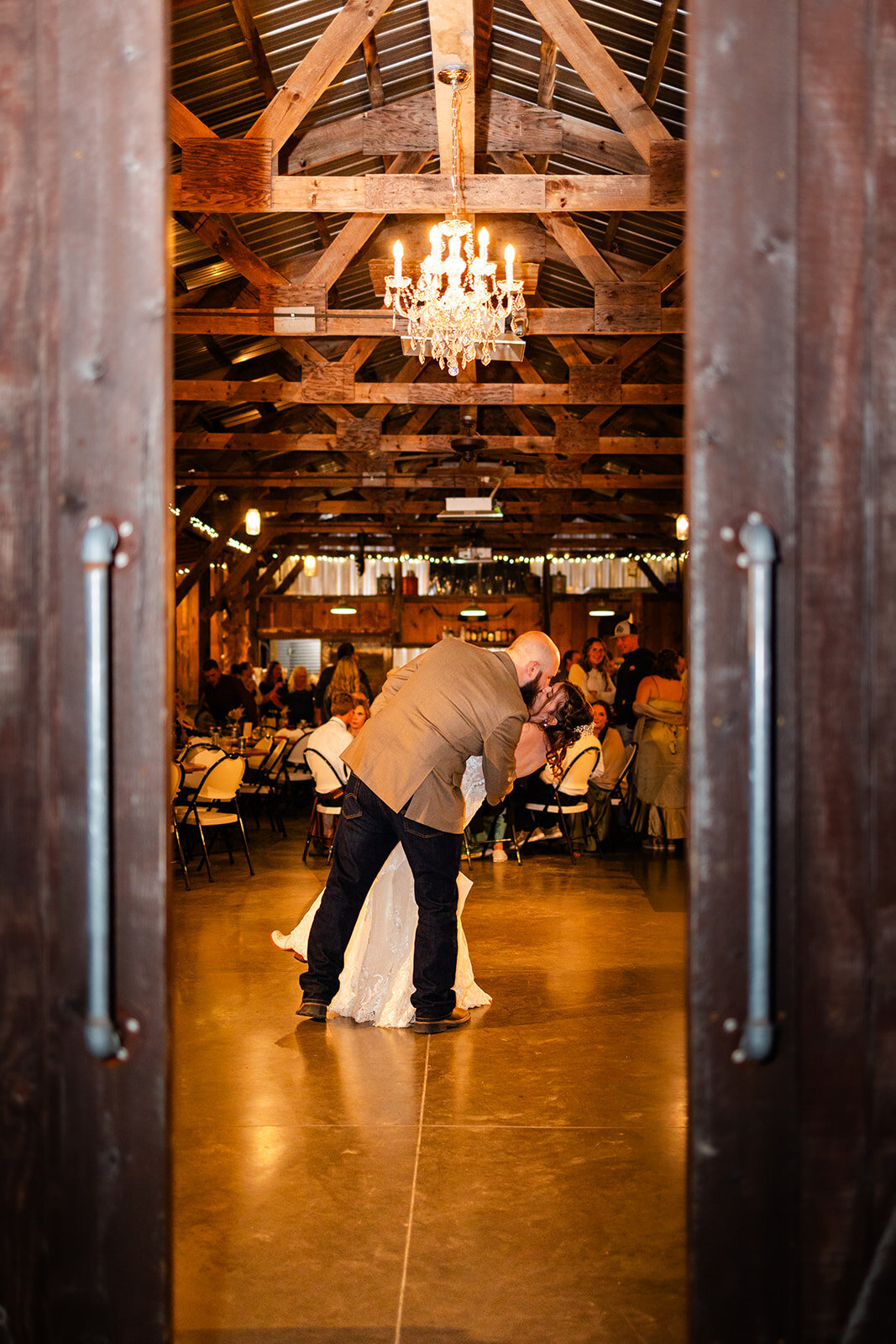 A beautifully decorated reception space with handcrafted wooden tables, string lights, and dancing at Echo Valley Sawmill.