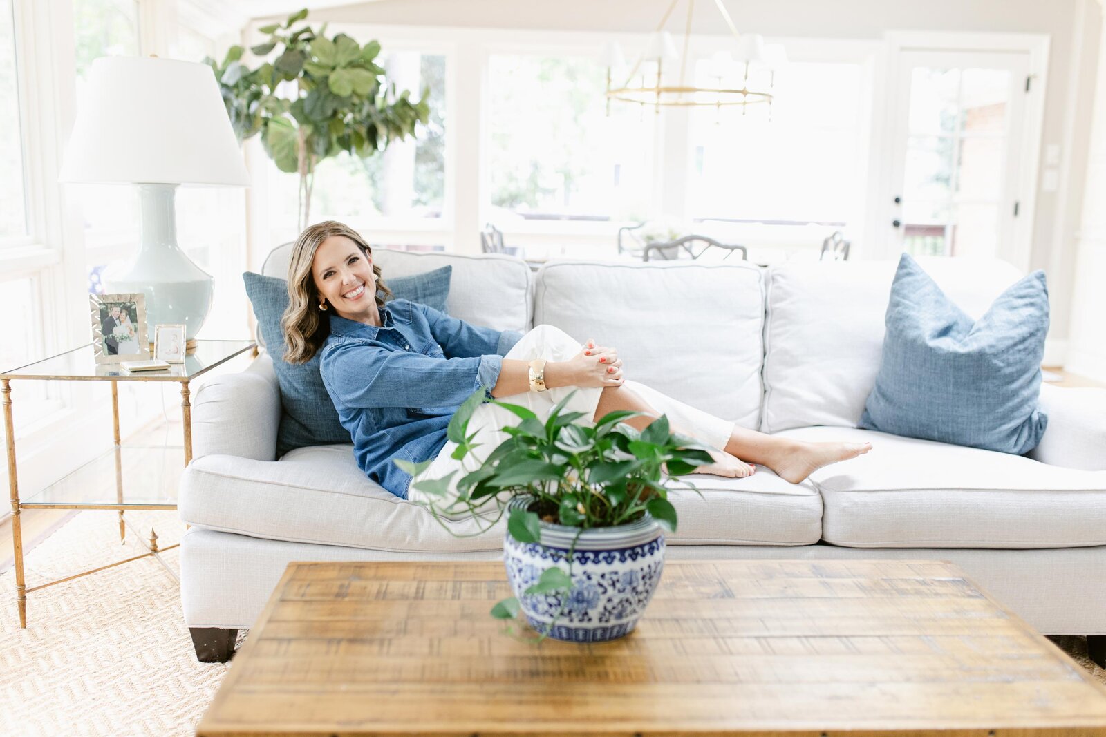 Jennifer Kelley Smiling and laying back on her couch in her living room | Health and Mindset Coach for Women and Moms