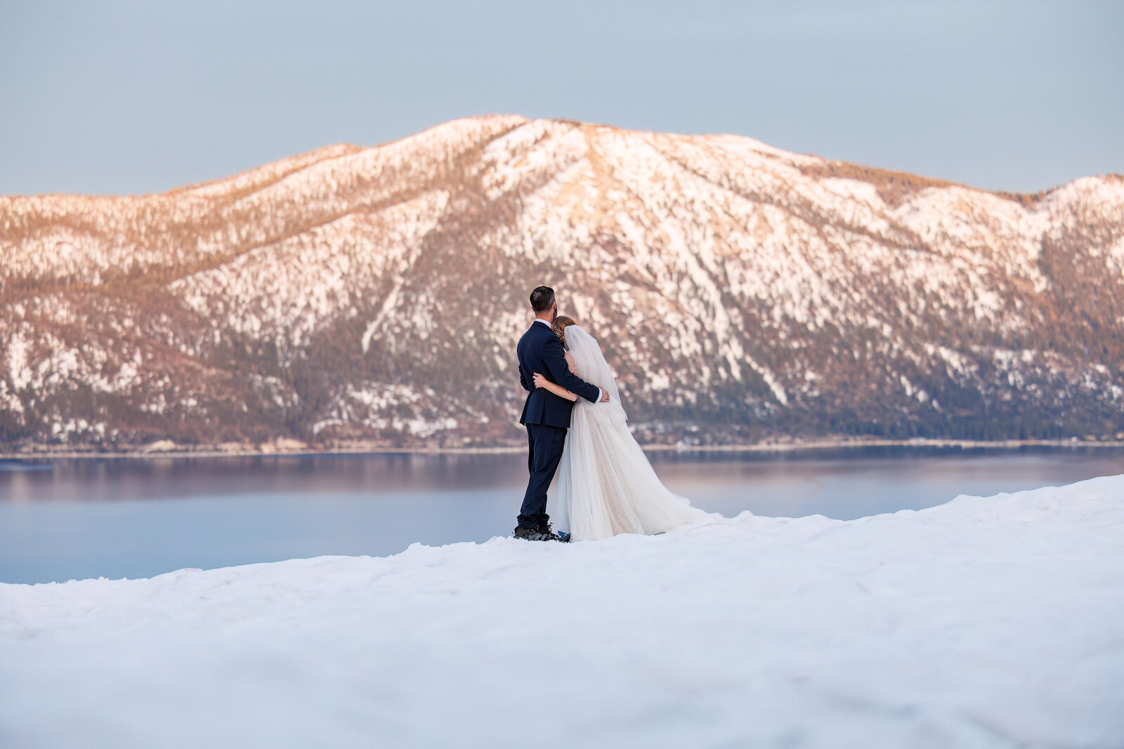 a wedding couple looks at the sunset in Lake Tahoe